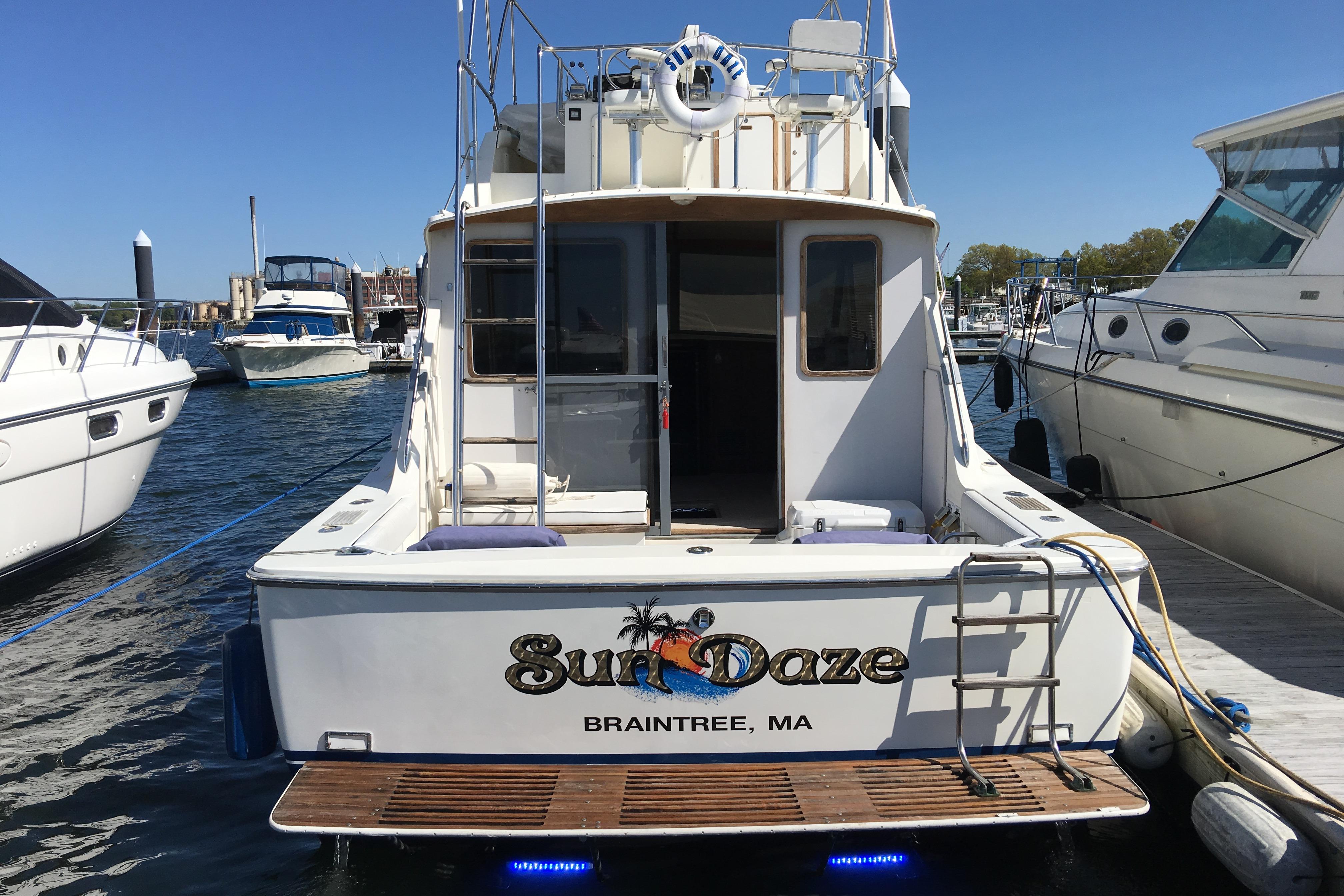 1985 Bertram 33 Flybridge Cruiser docked, featuring "Sun Daze" name, Braintree, MA.