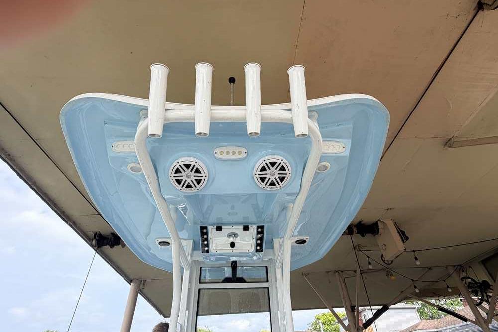 2024 Tidewater 232 LXF boat with blue T-top and rod holders.