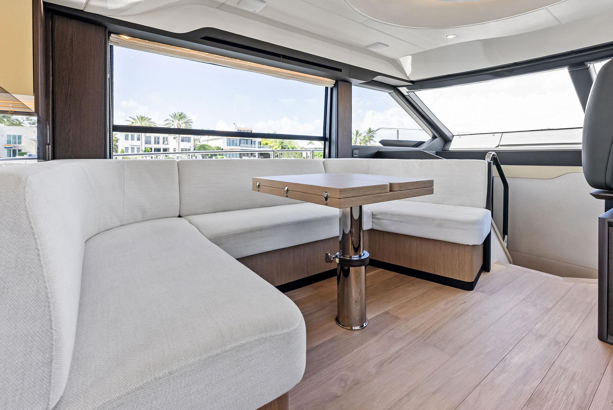 Luxurious interior of 2023 Absolute 52 FLY yacht with modern seating and panoramic windows.