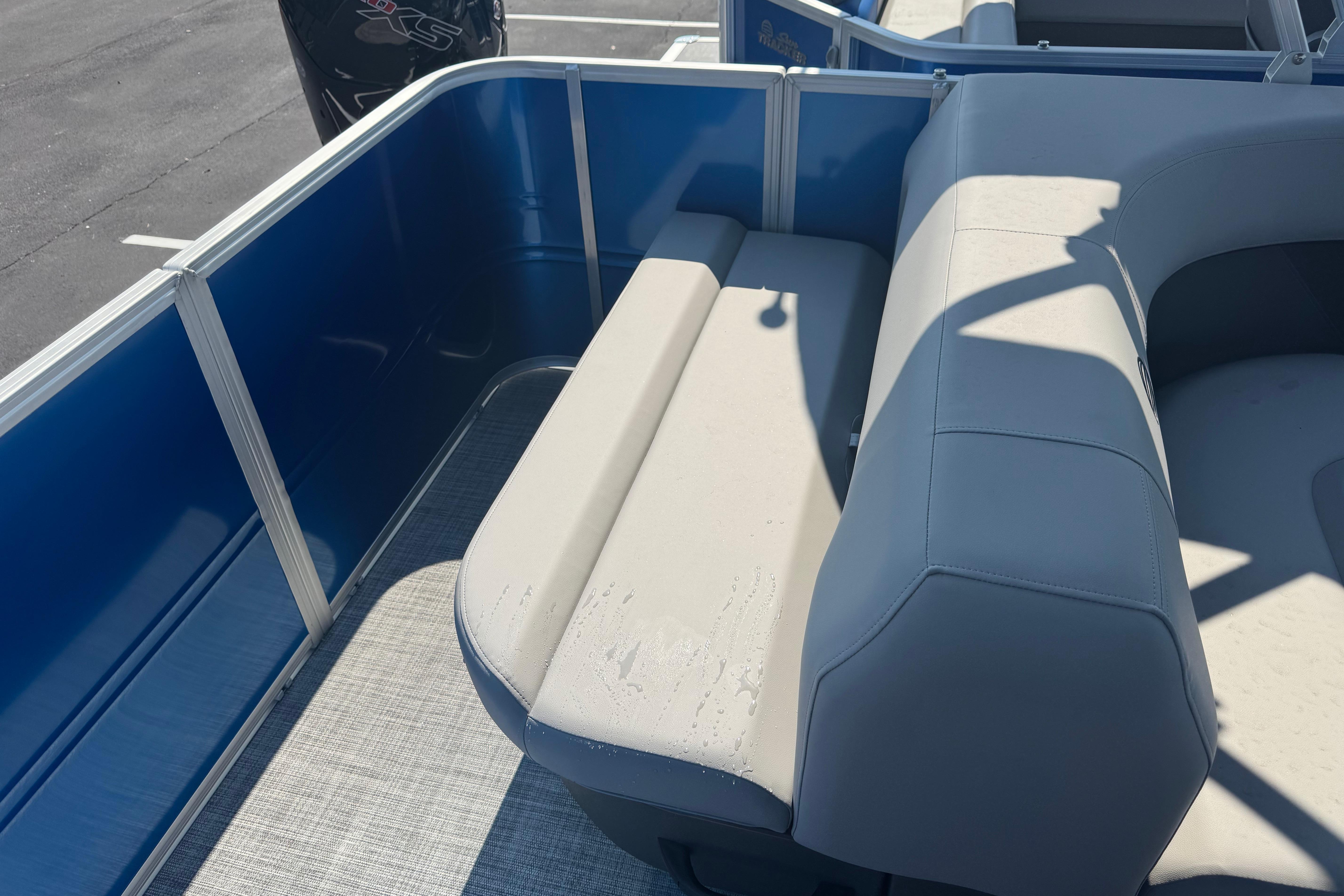 2026 Sun Tracker Party Barge 18 DLX, blue and gray seating area, outdoor setting.