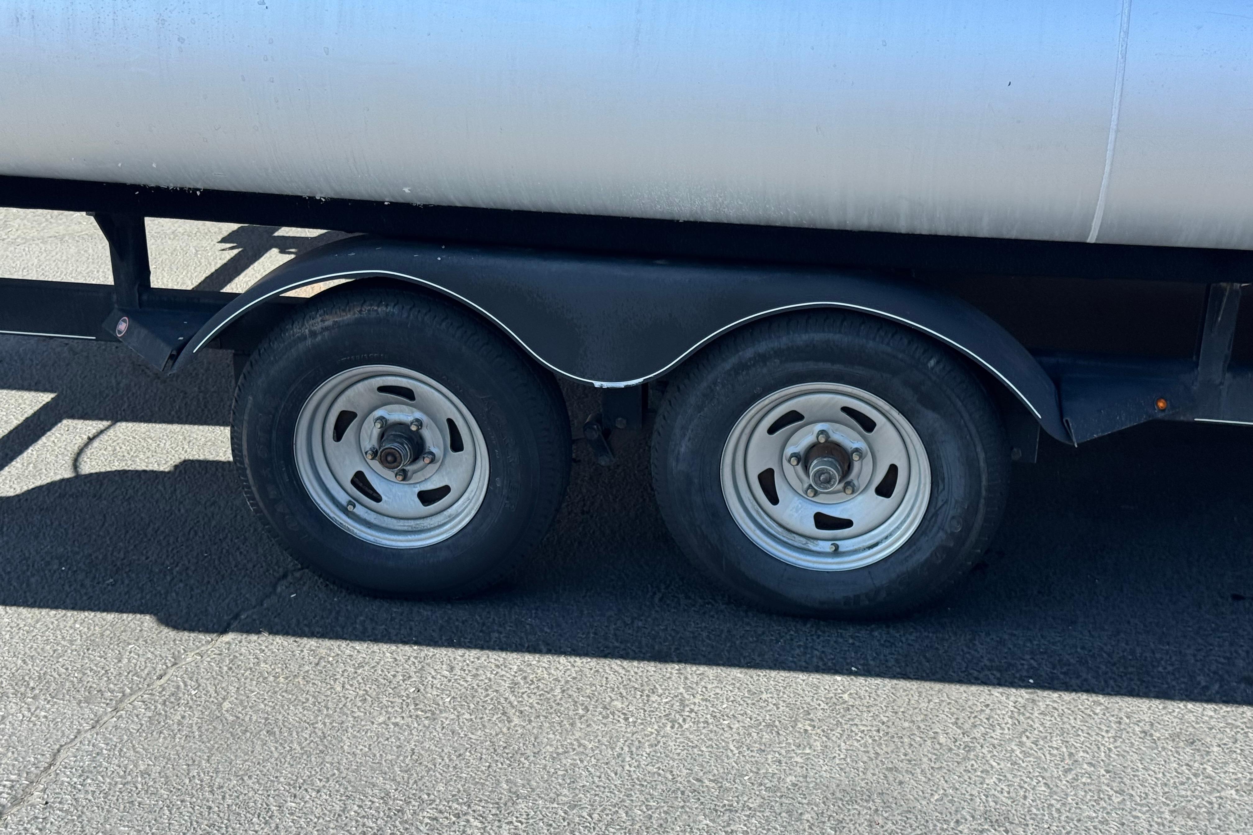 Trailer wheels of a 2018 Sun Tracker SportFish 22 DLX on pavement.