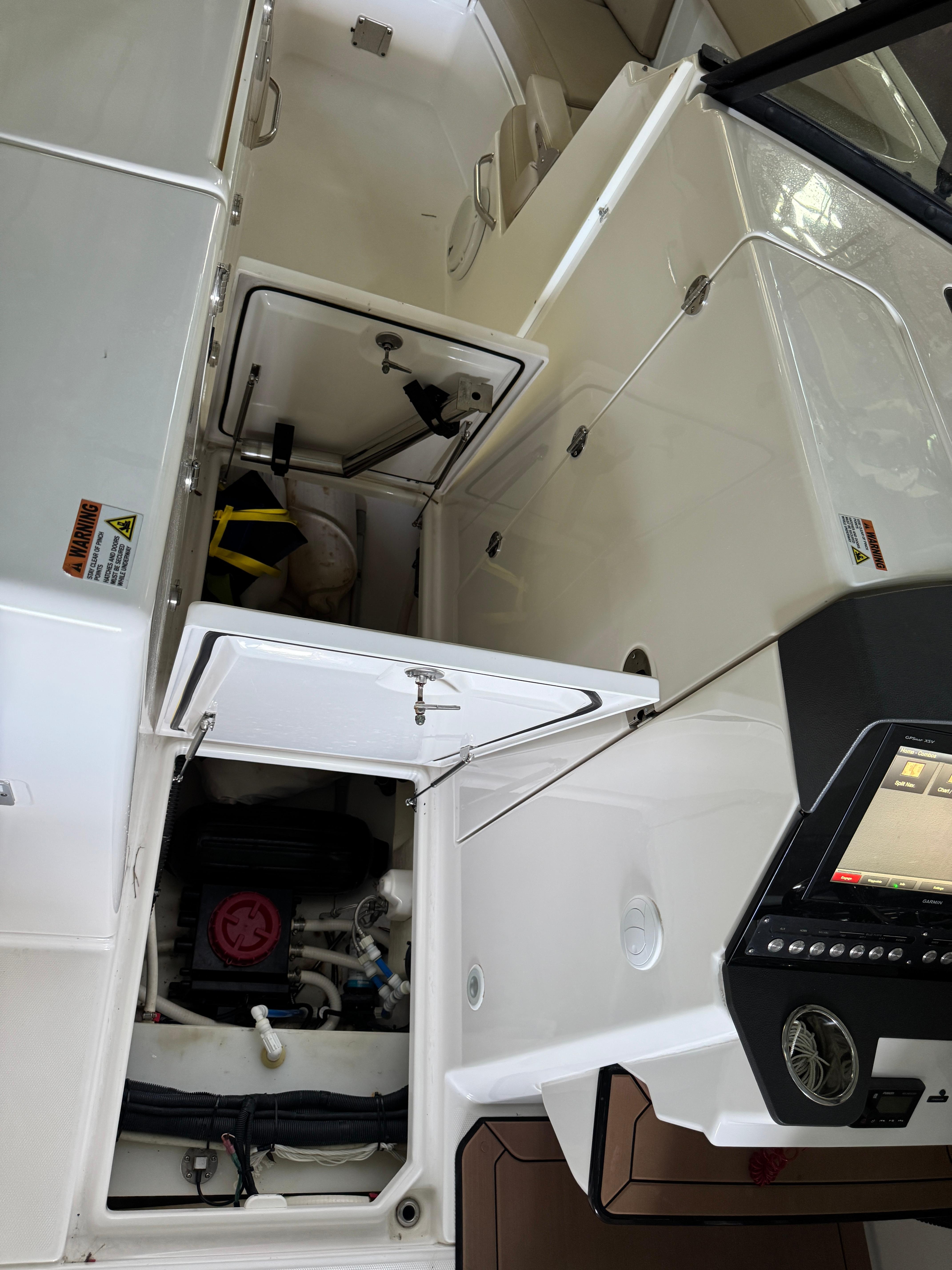 Interior view of a 2019 Everglades 340 Dual Console boat, showcasing storage compartments.