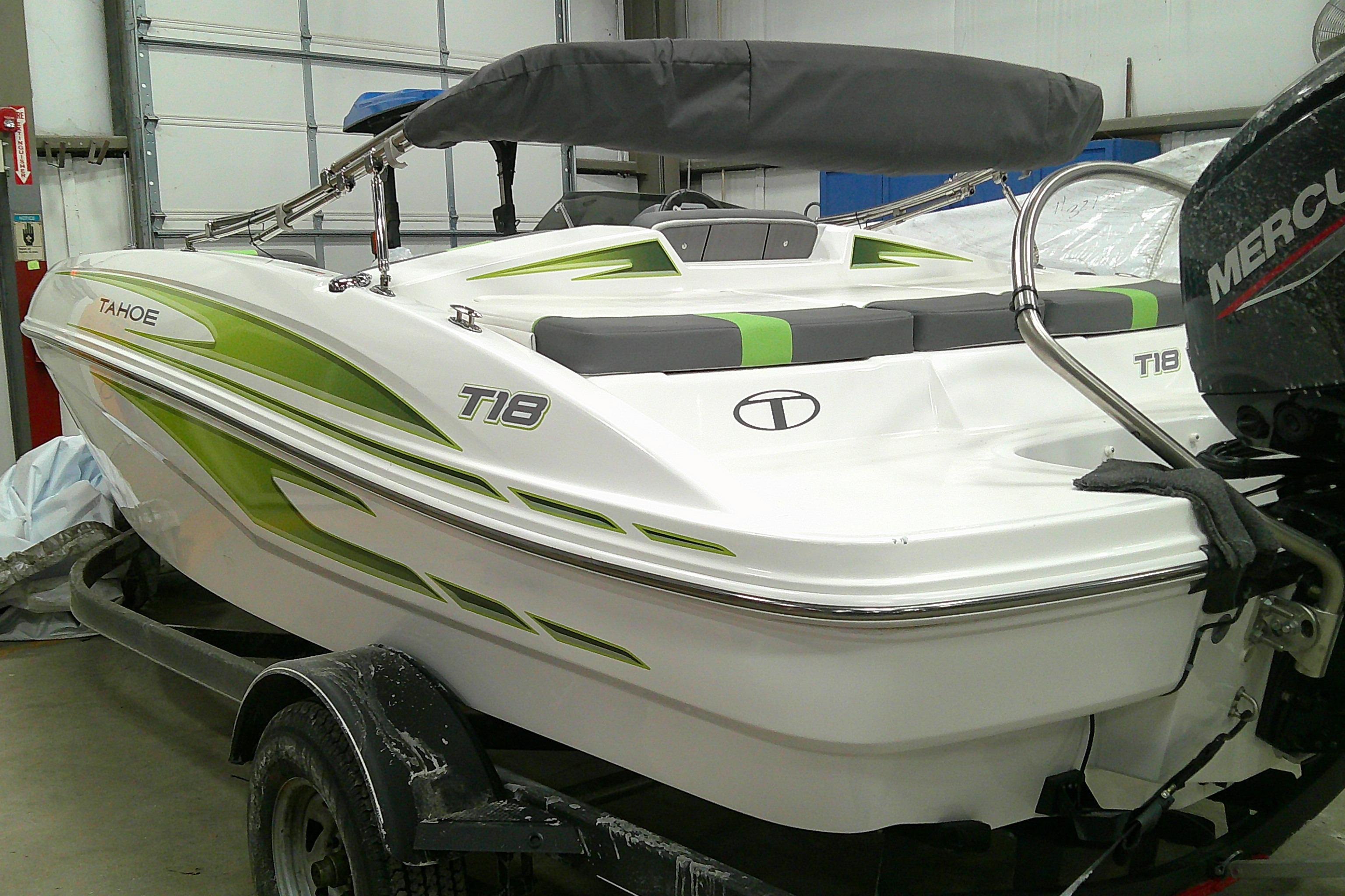 2023 Tahoe T18 boat with green accents in a garage setting.