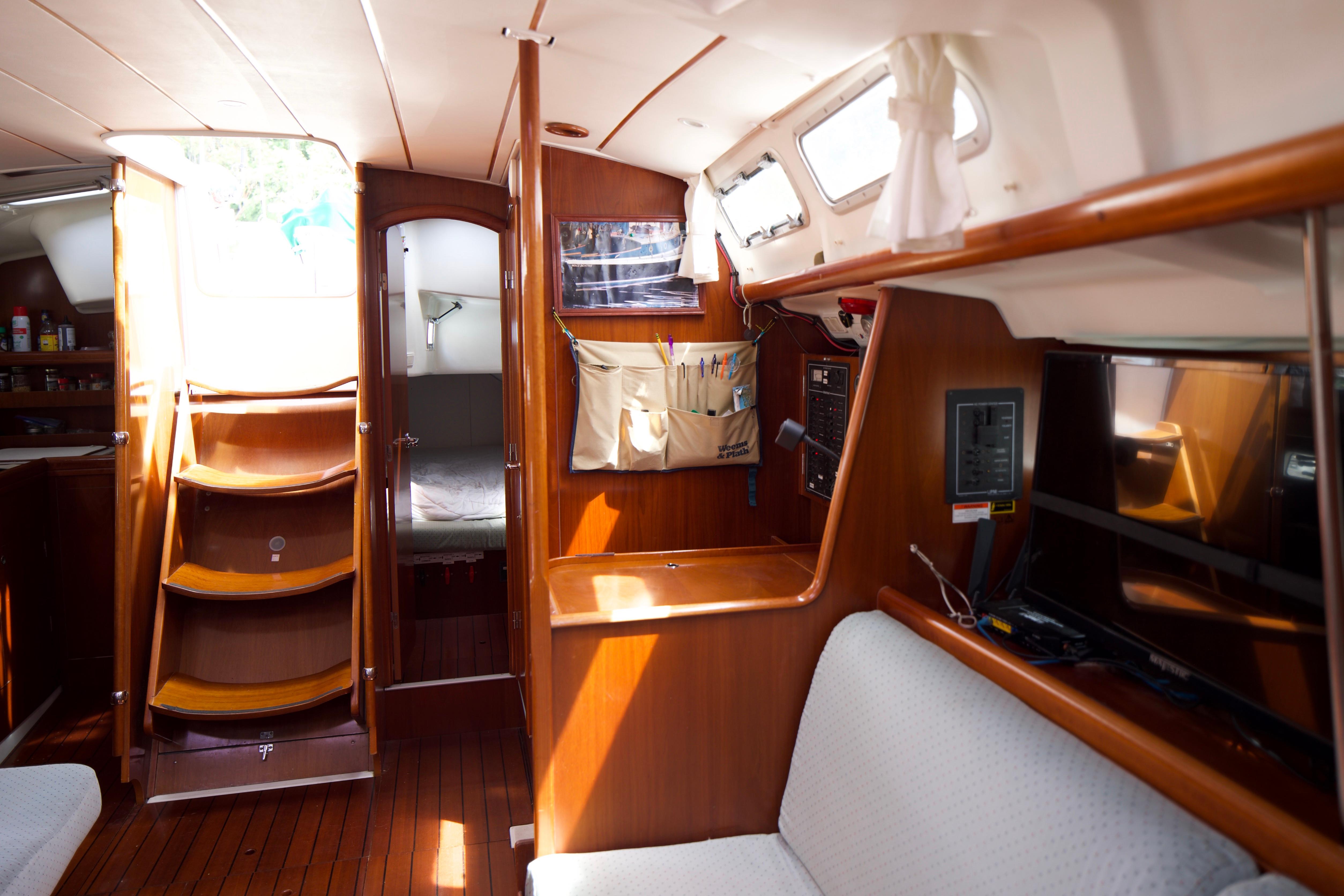 Interior of 2005 Beneteau 423 yacht with wooden finish and cozy seating area.