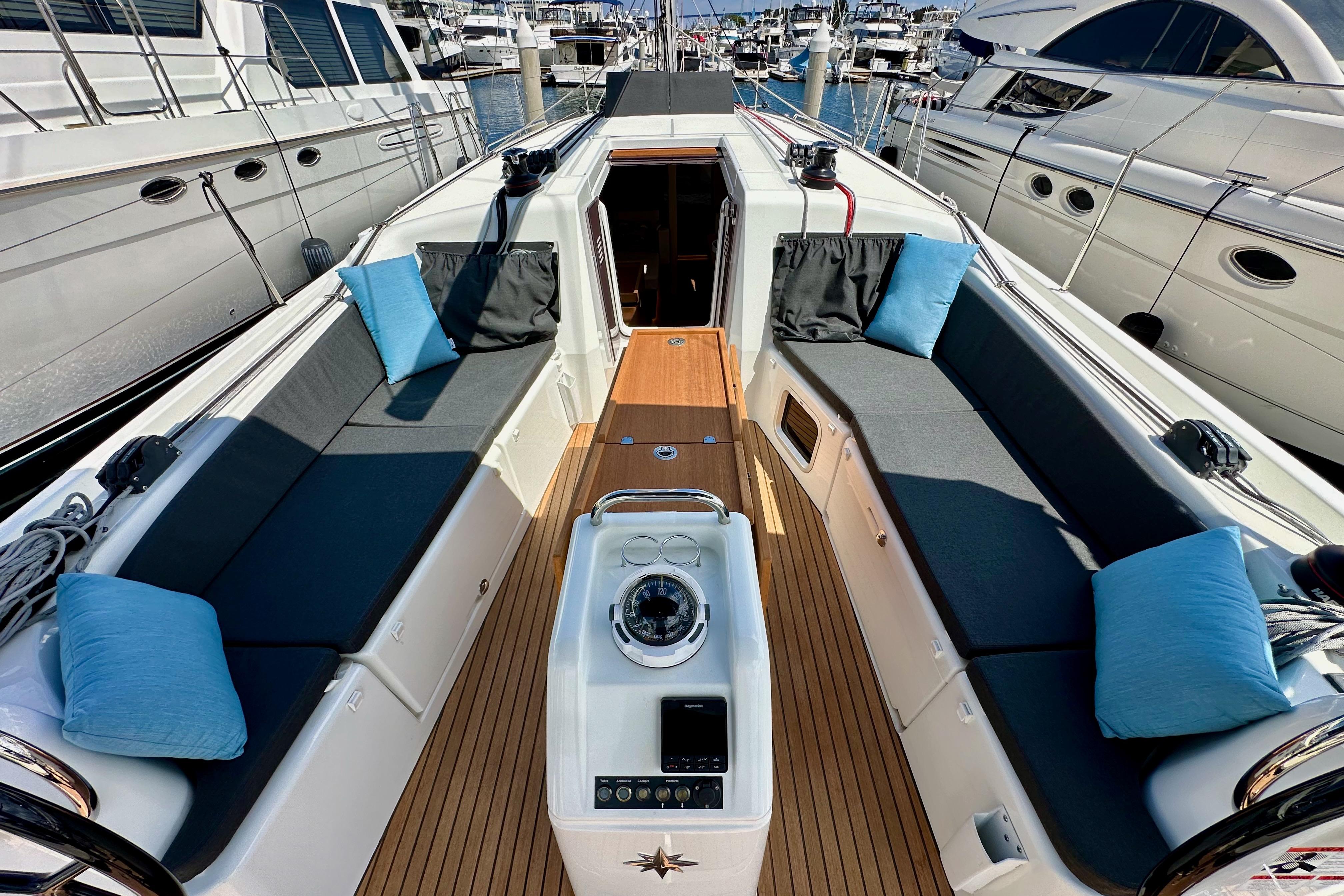 2024 Jeanneau Sun Odyssey 410 yacht cockpit with cushioned seating and teak flooring.