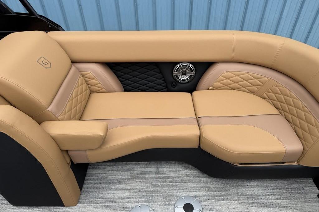 Luxurious tan seating on 2026 Godfrey Monaco 235 SFLC iMPACT boat, featuring quilted design and speaker.