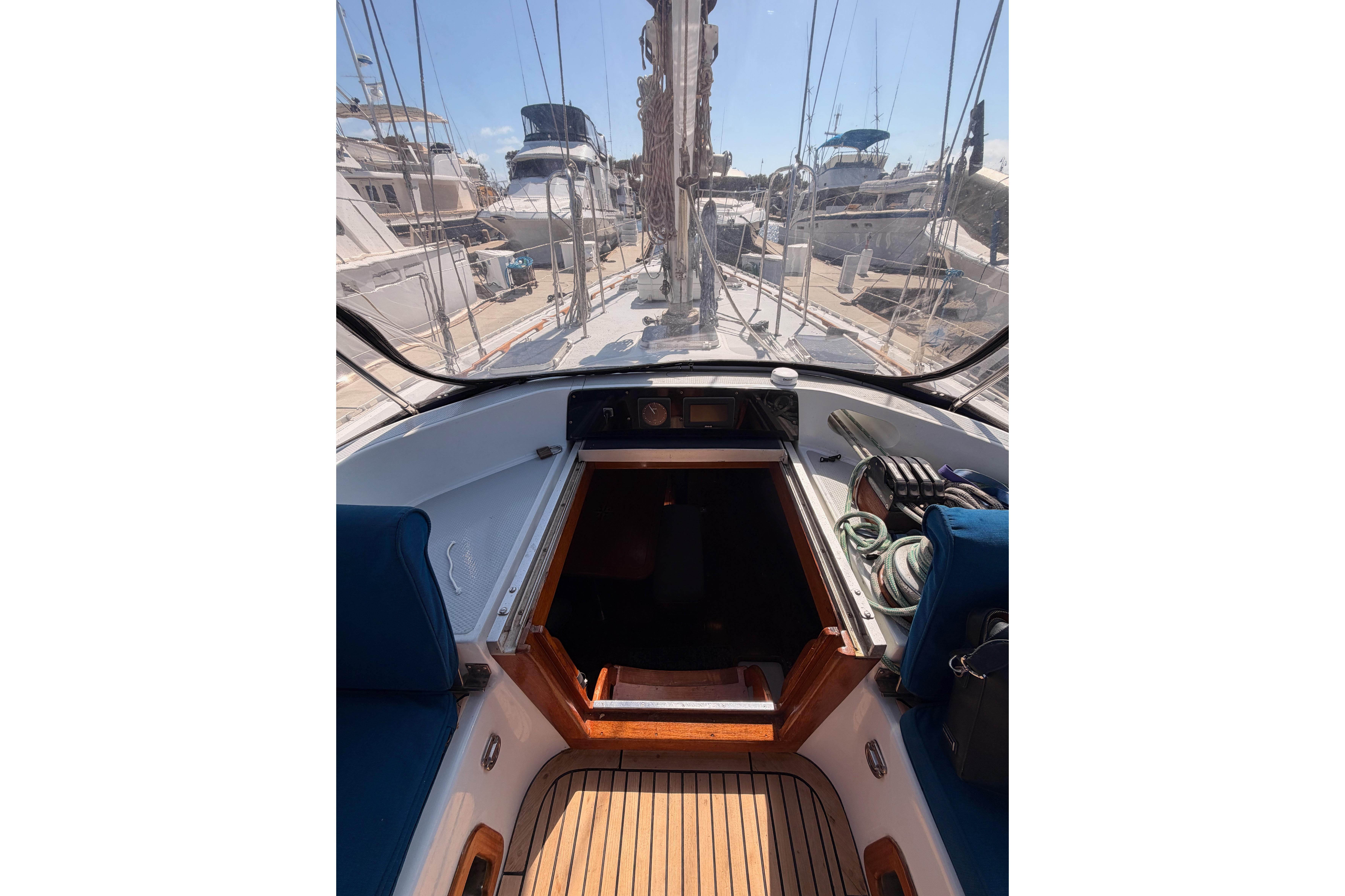 Cockpit view of a 1991 Hylas 51 sailboat, showcasing deck and marina surroundings.