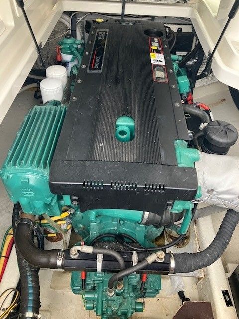 An engine inside a boat, surrounded by hoses and cables.