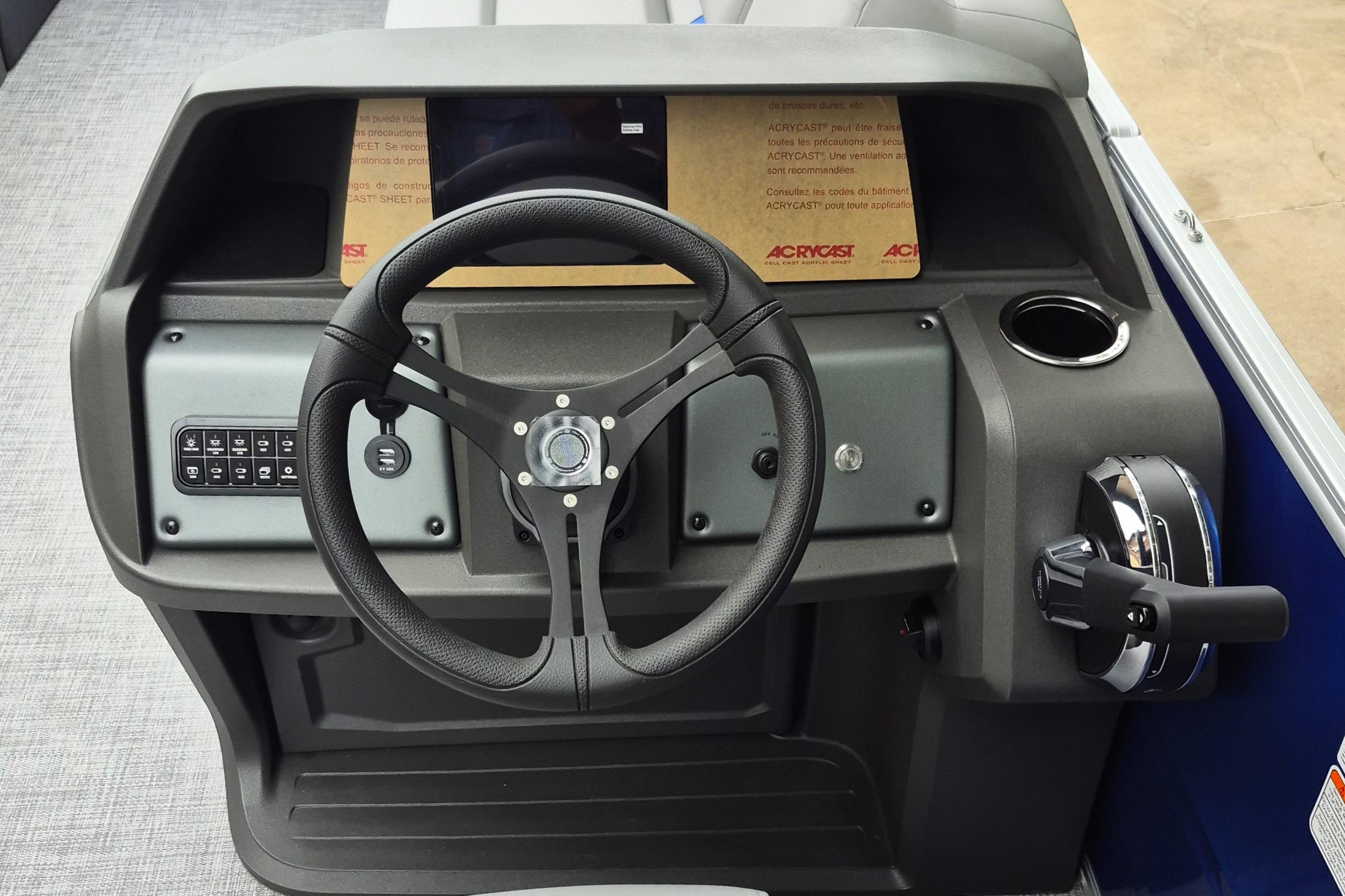 2026 Sun Tracker Party Barge 20 DLX helm with steering wheel and control panel.