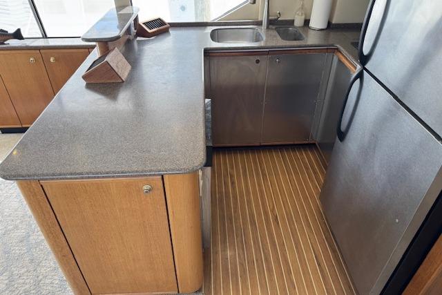 Kitchen area of 2000 Bayliner 5288 Pilot House Motoryacht with wood cabinets and stainless steel appliances.