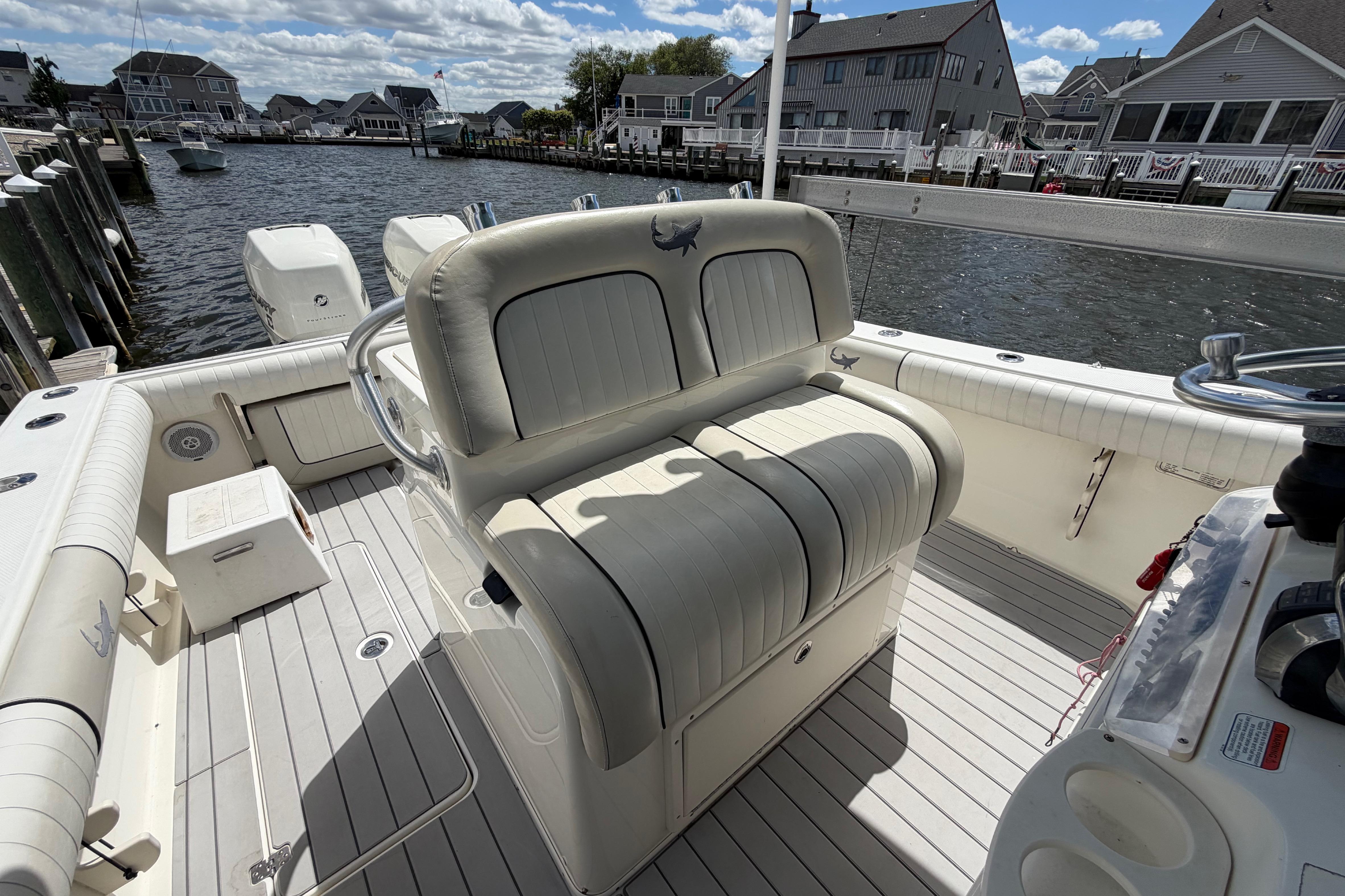 2017 Mako 284 Center Console boat docked, featuring spacious seating and dual outboard engines.