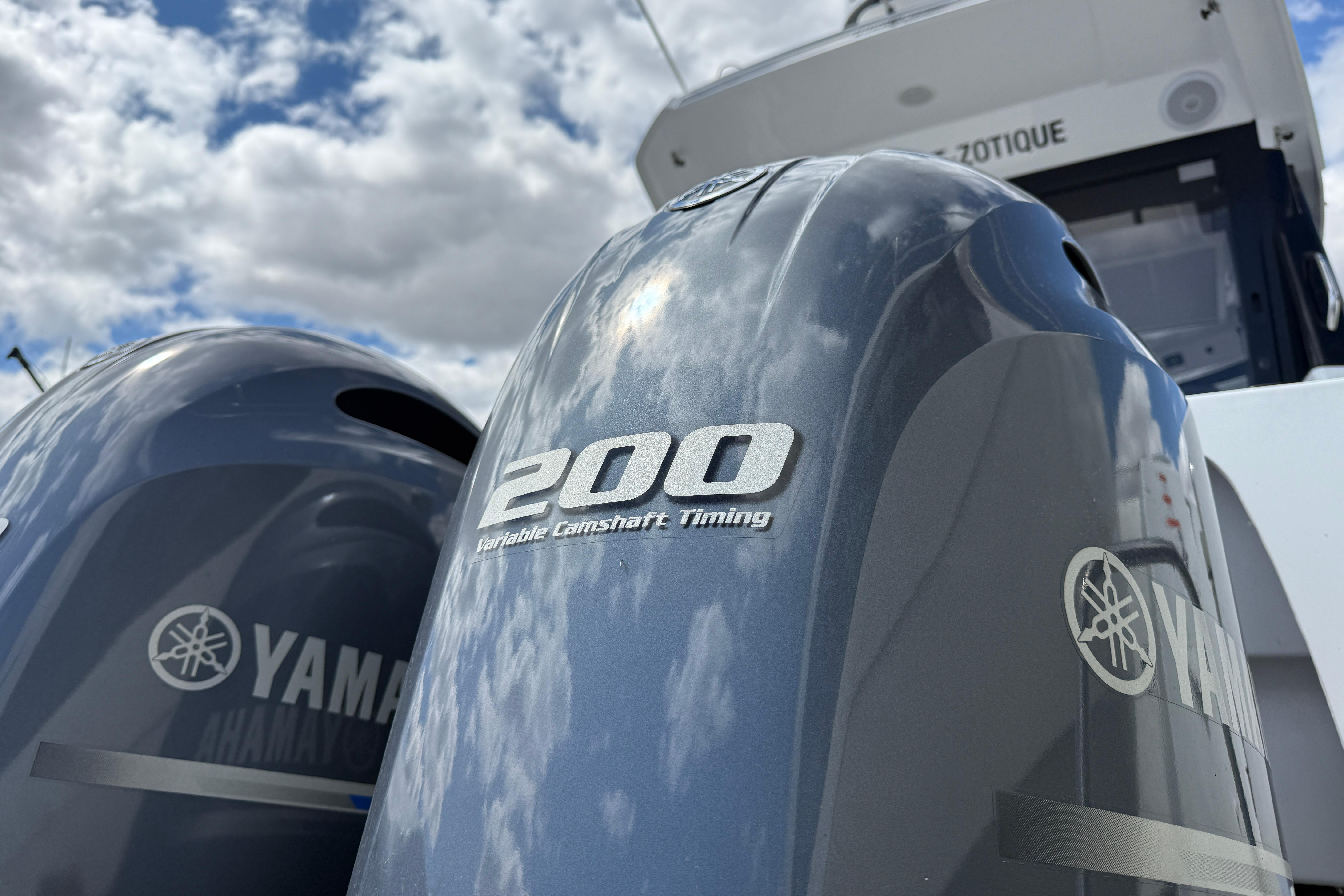 Yamaha 200 horsepower outboard engines on a 2021 Jeanneau NC 895 boat under cloudy sky.