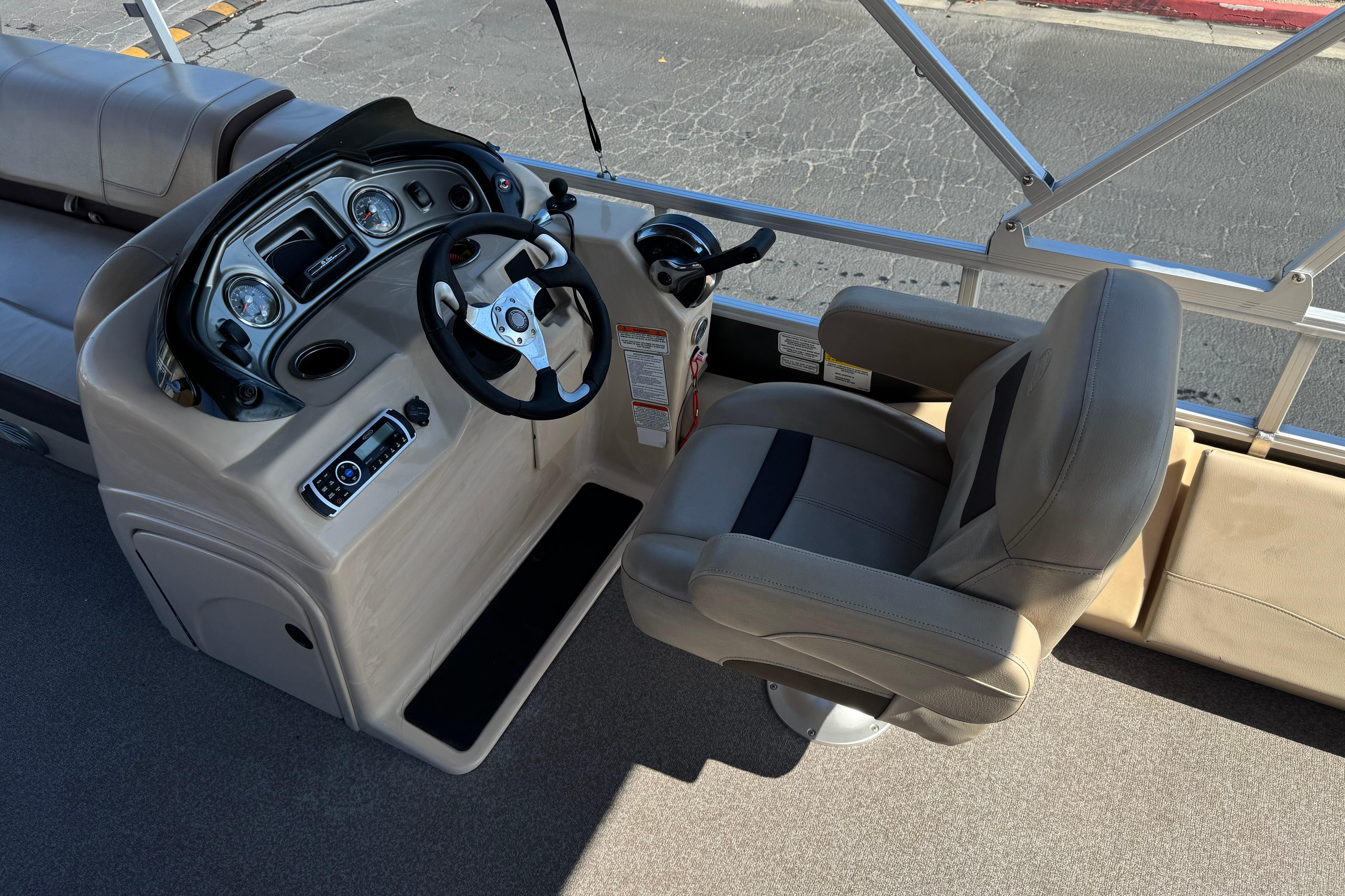 2018 Sun Tracker SportFish 22 DLX boat cockpit with steering wheel and captain's chair.