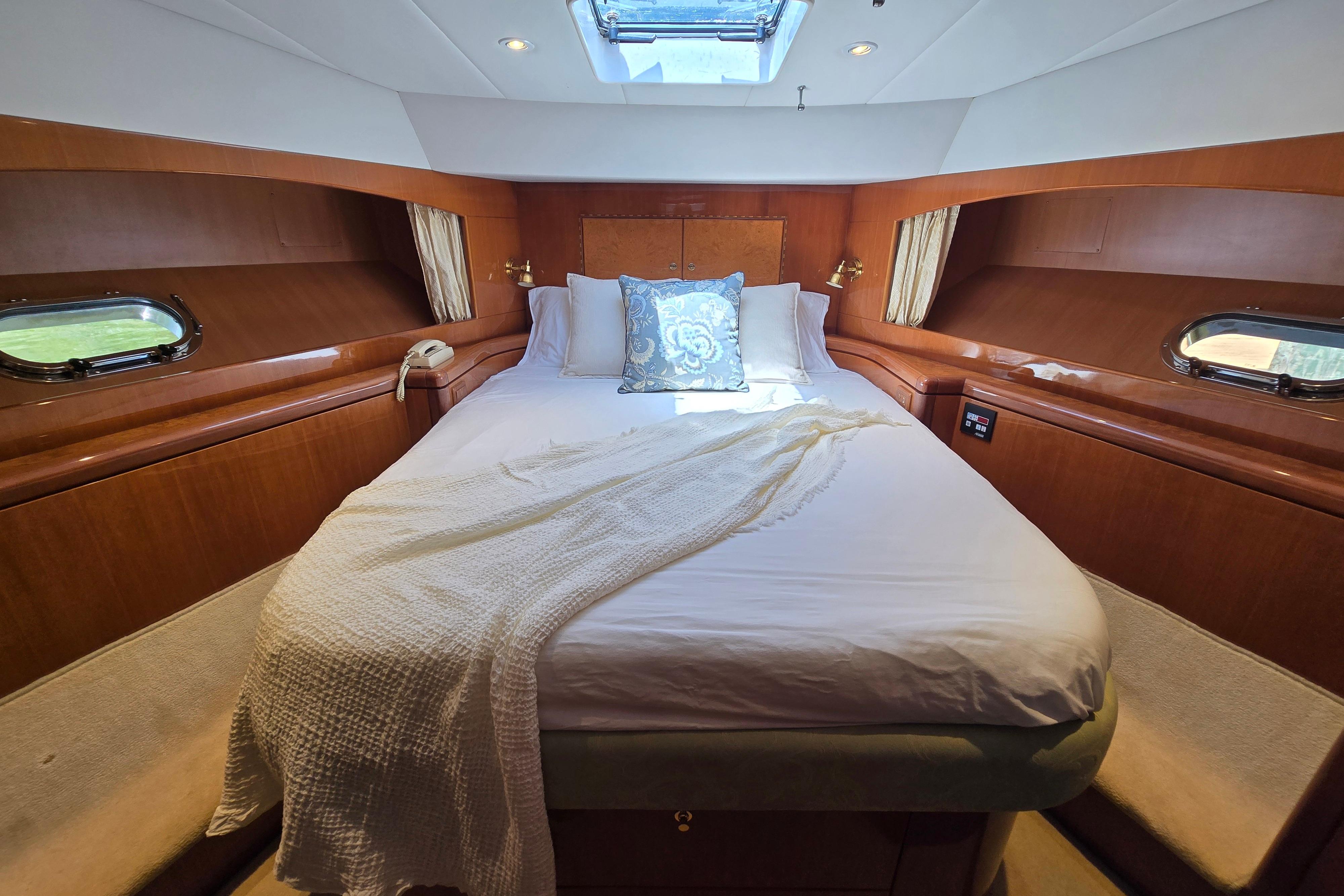 Luxurious cabin interior of 2004 Grand Harbour 58 yacht with cozy bed and elegant decor.