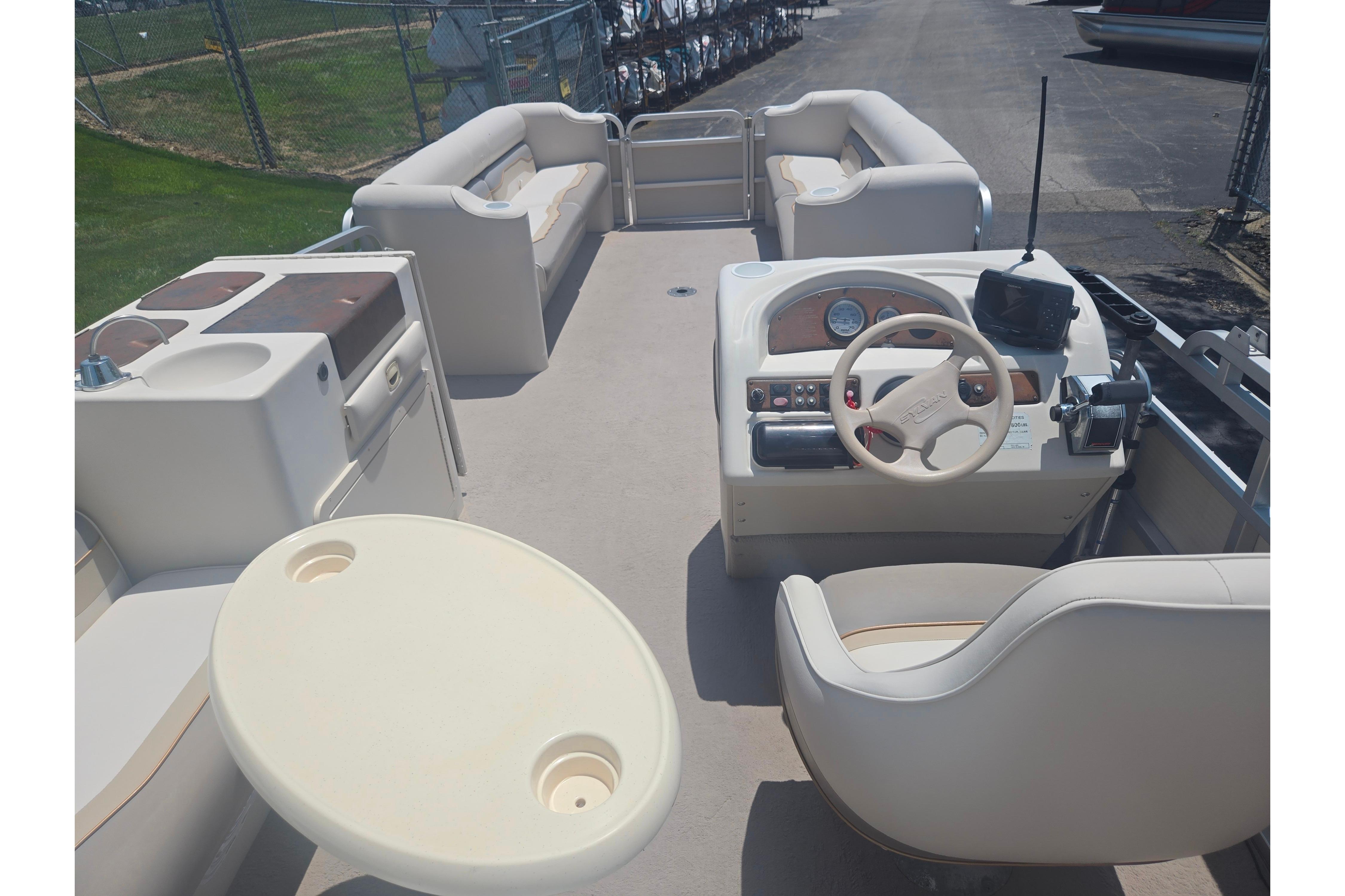 Interior of 2000 Sylvan 824 Elite Cruise pontoon boat with seating and helm.