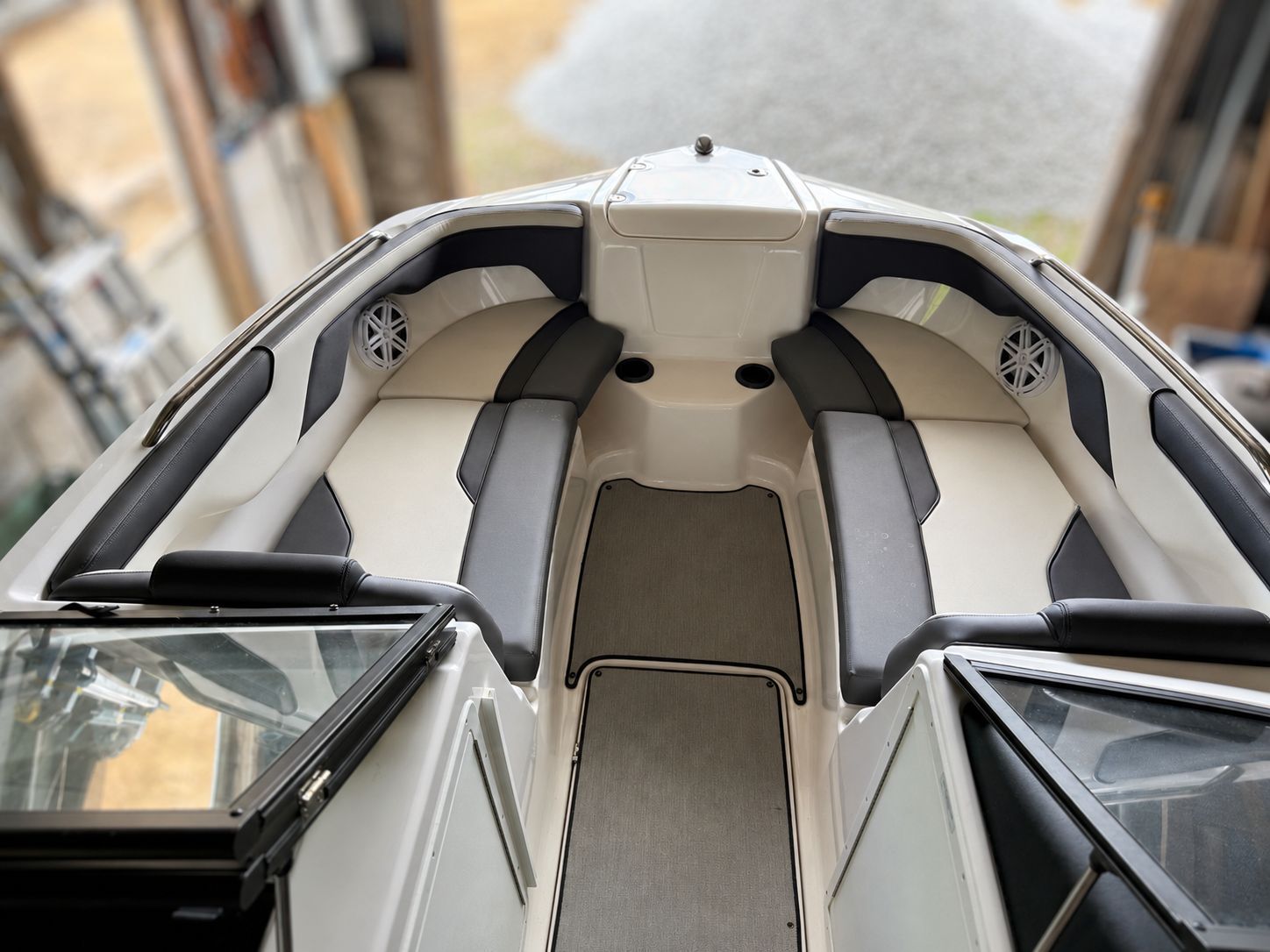 The image shows the bow area of a 2021 Yamaha SX210 boat with cushioned seating and speakers.