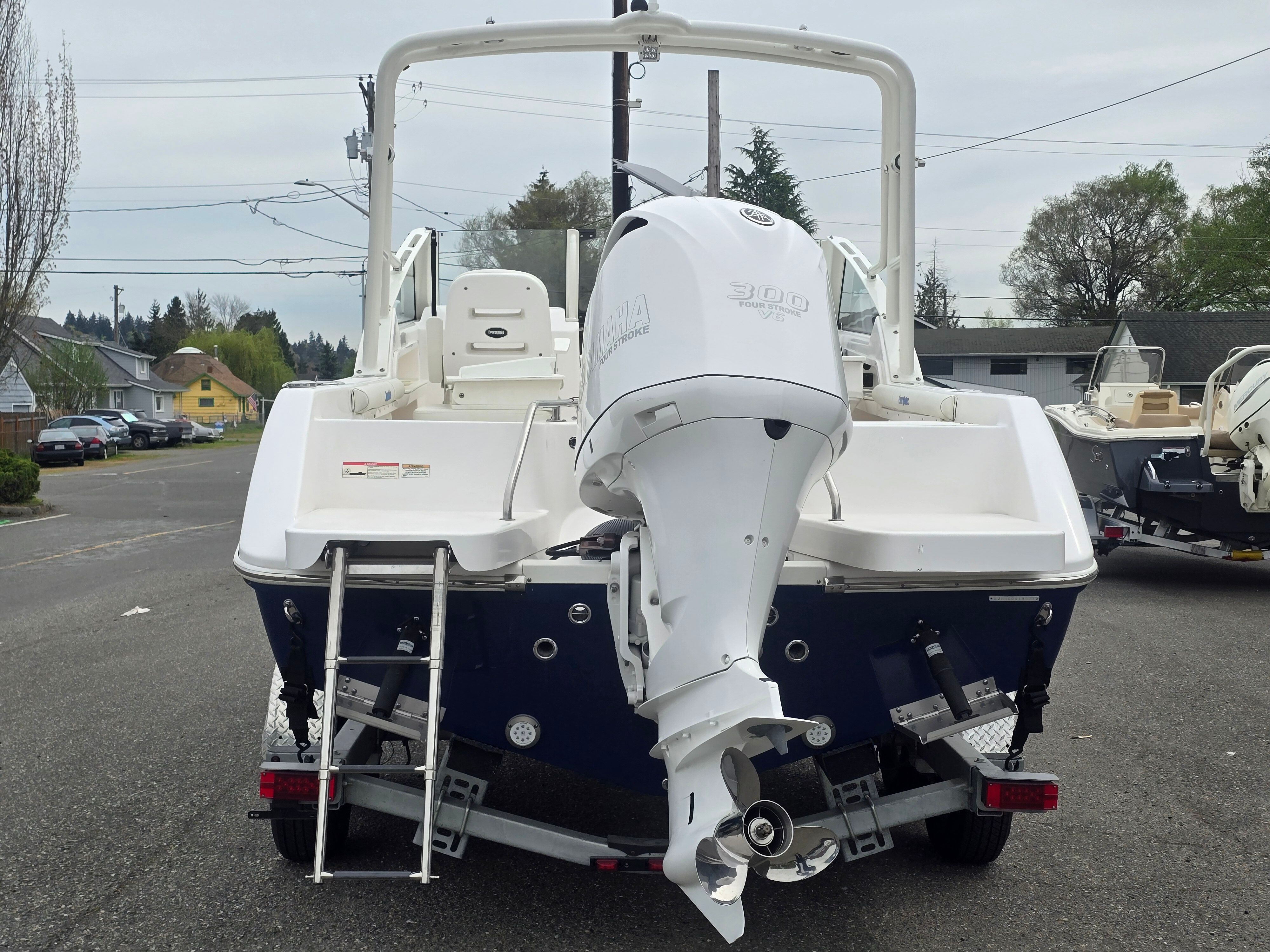 Rear view of an Everglades 230 Dual Console boat with outboard motor and swim ladder.
