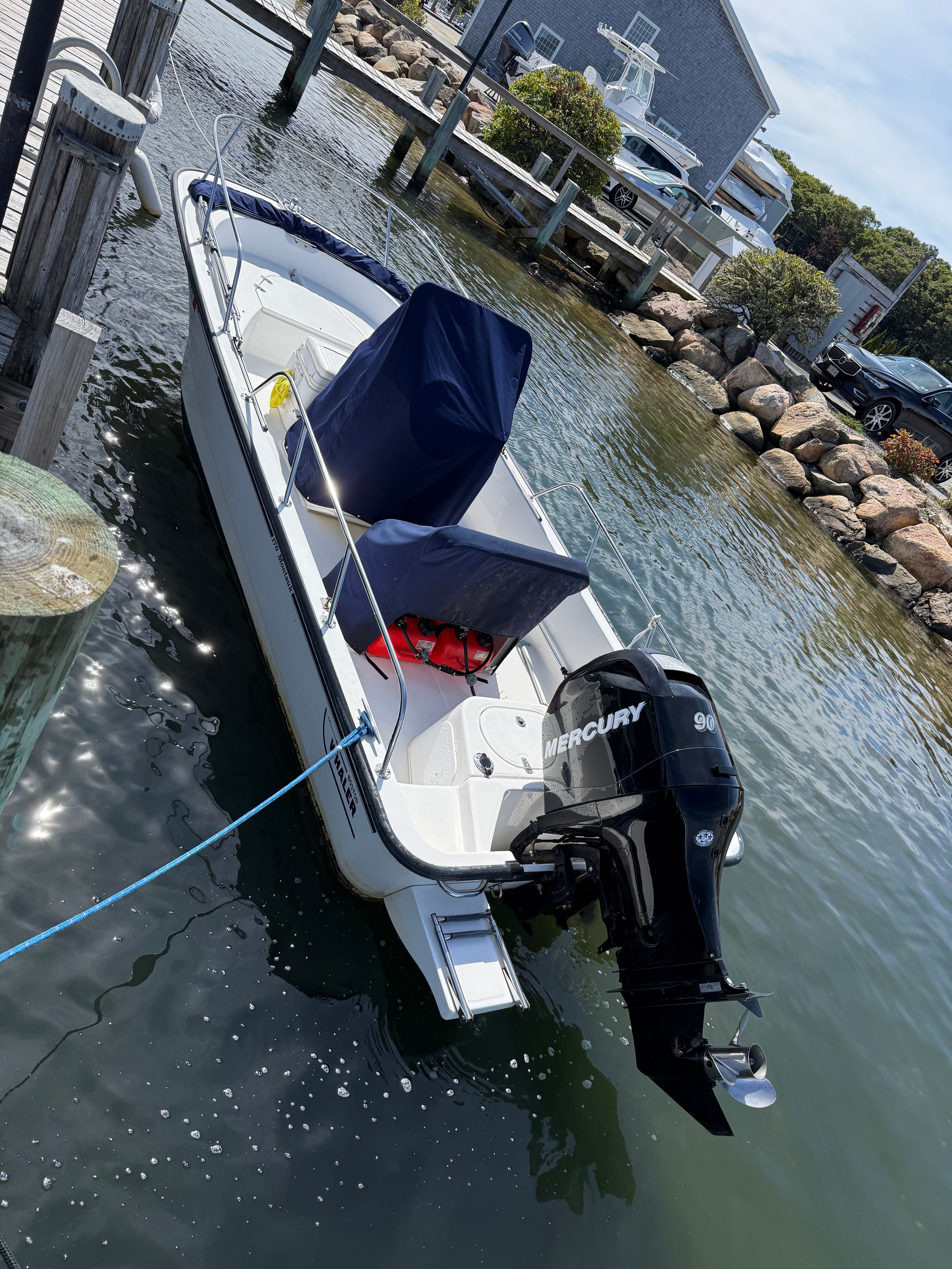 A 2011 Boston Whaler 170 Montauk is docked. It features a Mercury engine.