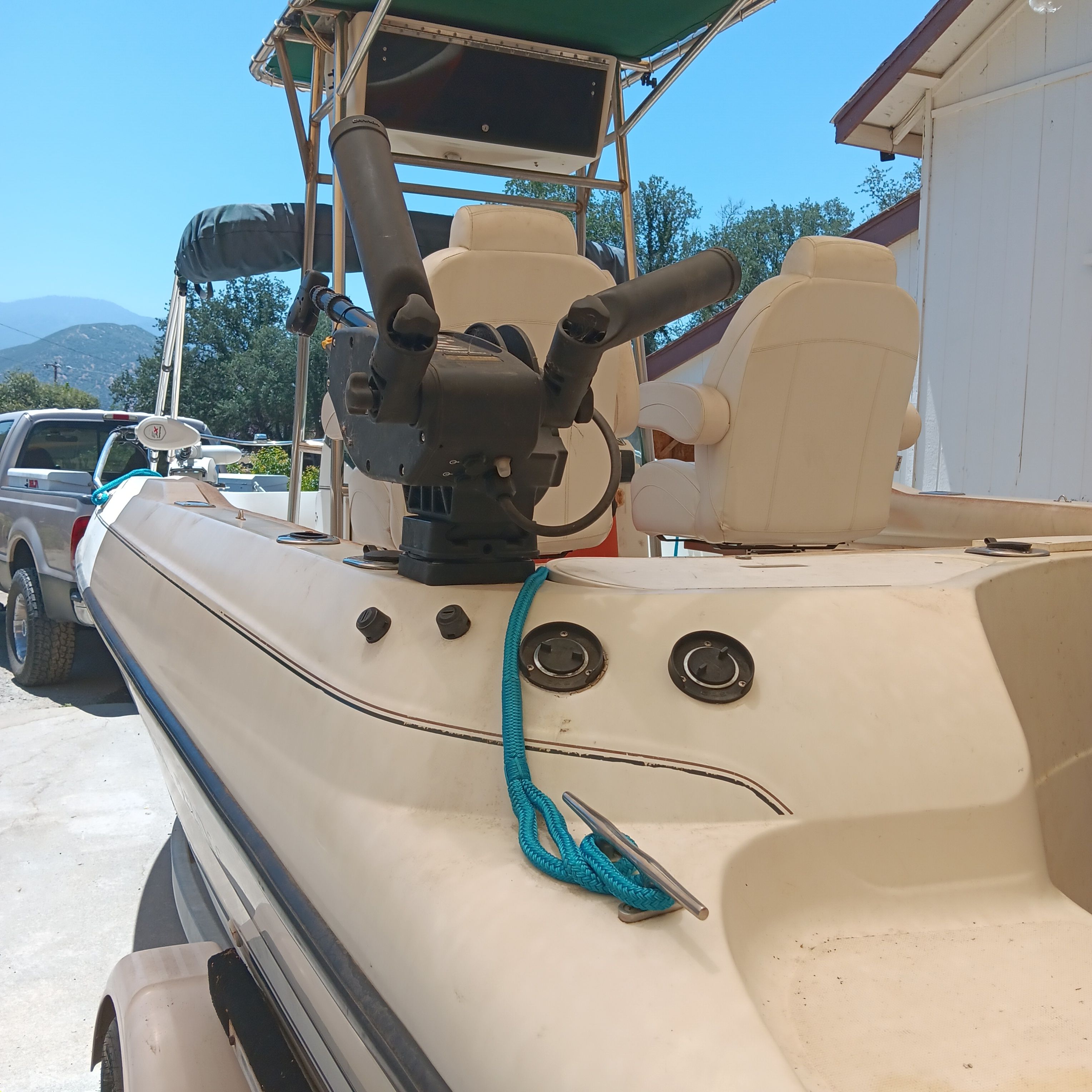 A 1998 Doral Ibiza 22 CC with white seats and blue rope, parked on land.