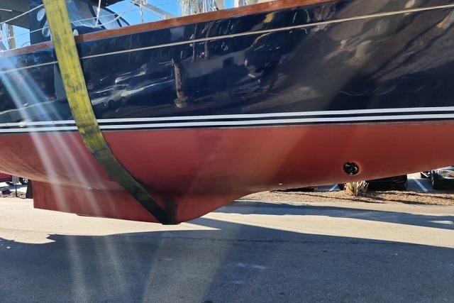 1984 Bristol 45.5 Center Cockpit sailboat hull in dry dock, showing red and blue paint.