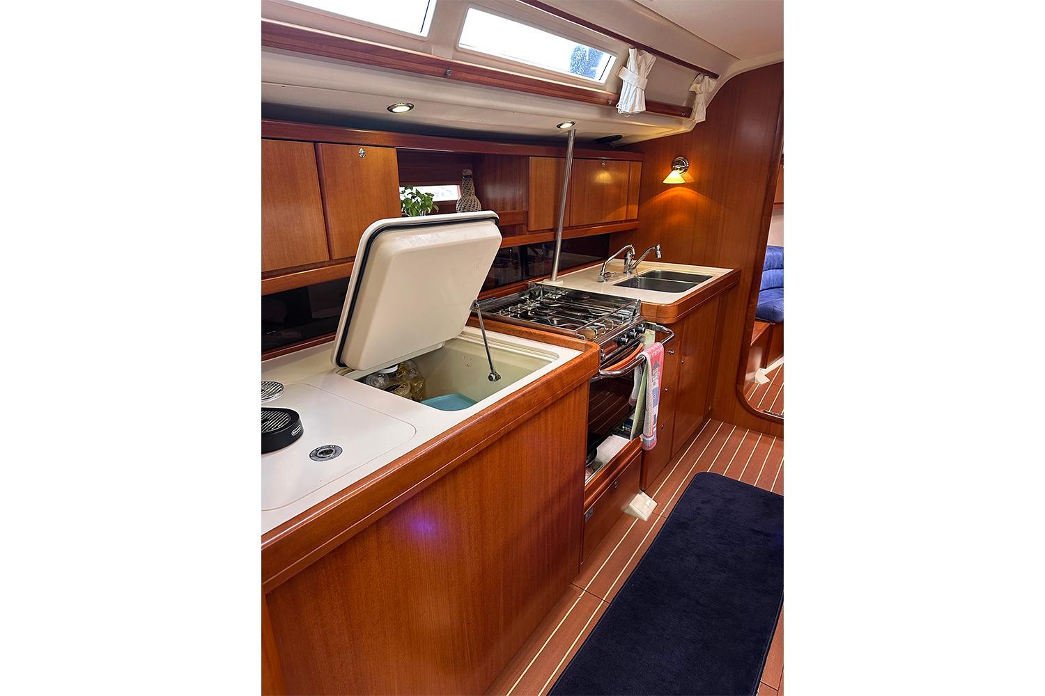 2007 Dufour 455 GL yacht kitchen with wood cabinetry, stove, and sink.