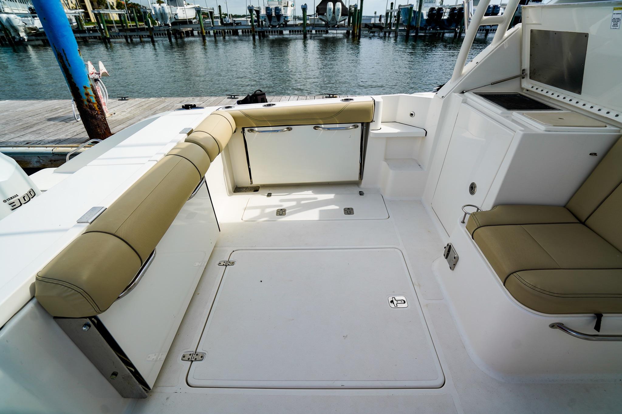 2020 Pursuit OS 325 Offshore boat interior with beige seating and dockside view.