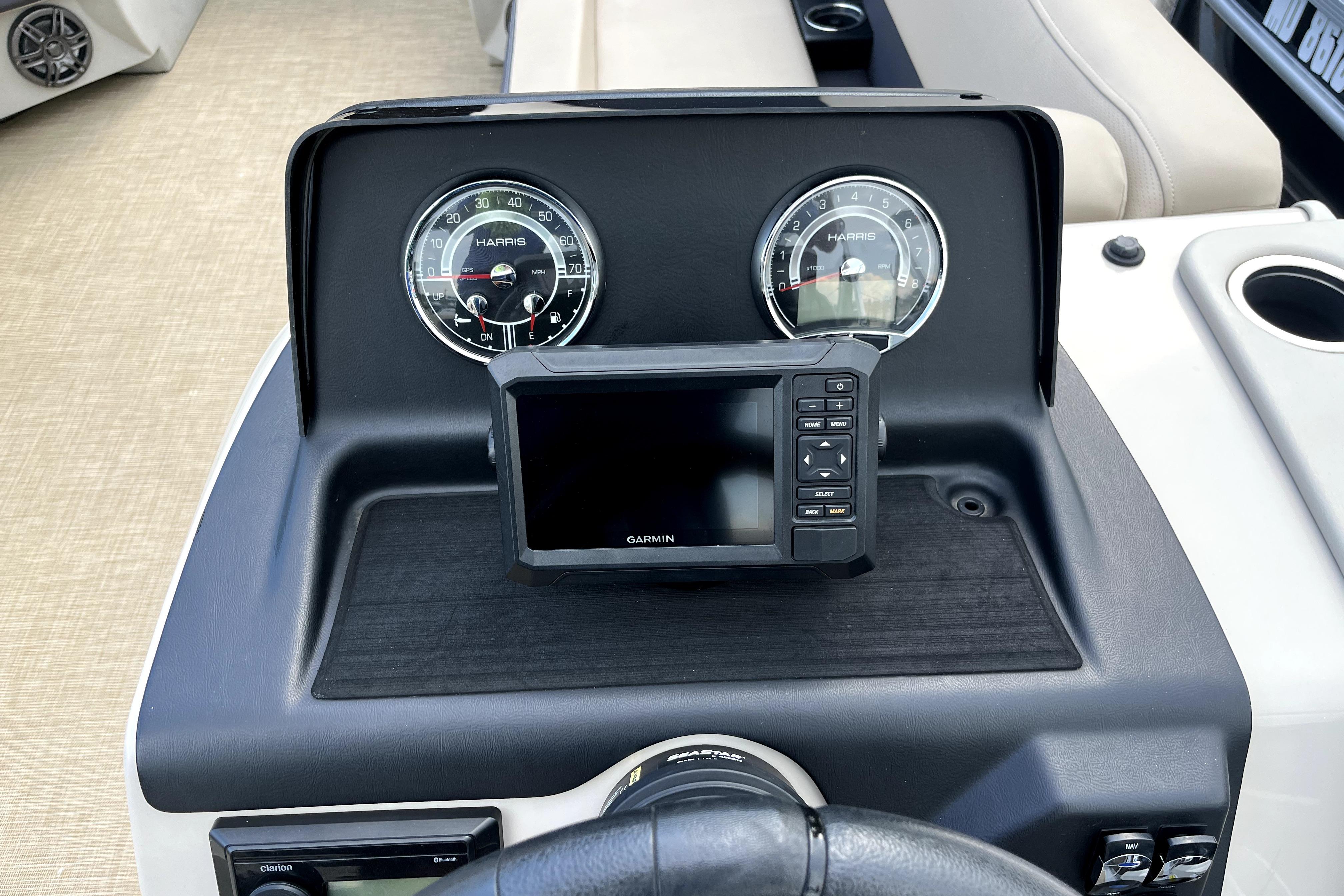 Dashboard of 2024 Harris HCX23 boat with Garmin display and gauges.