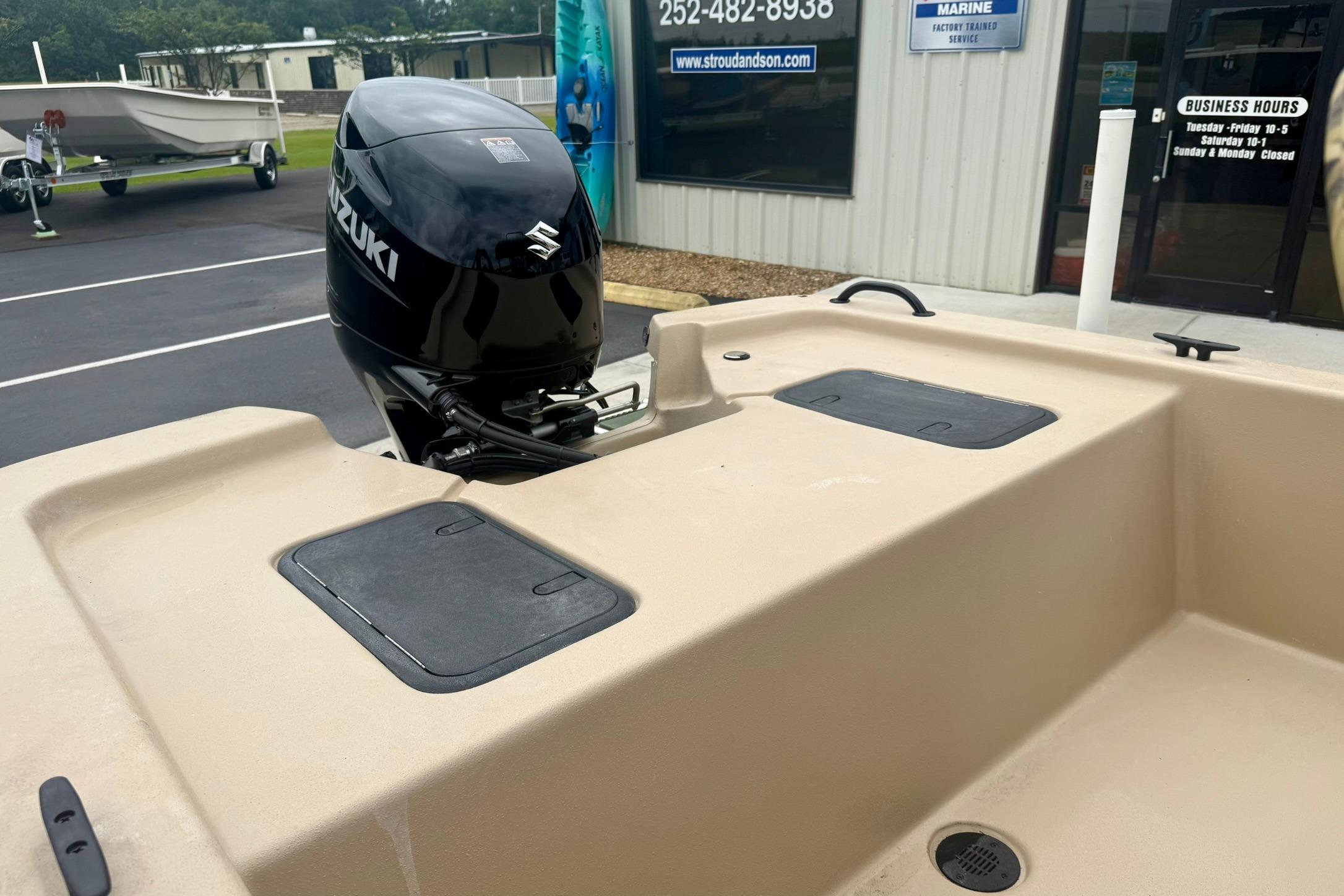 2026 Carolina Skiff E18 JVX CC boat with Suzuki outboard motor at a dealership.