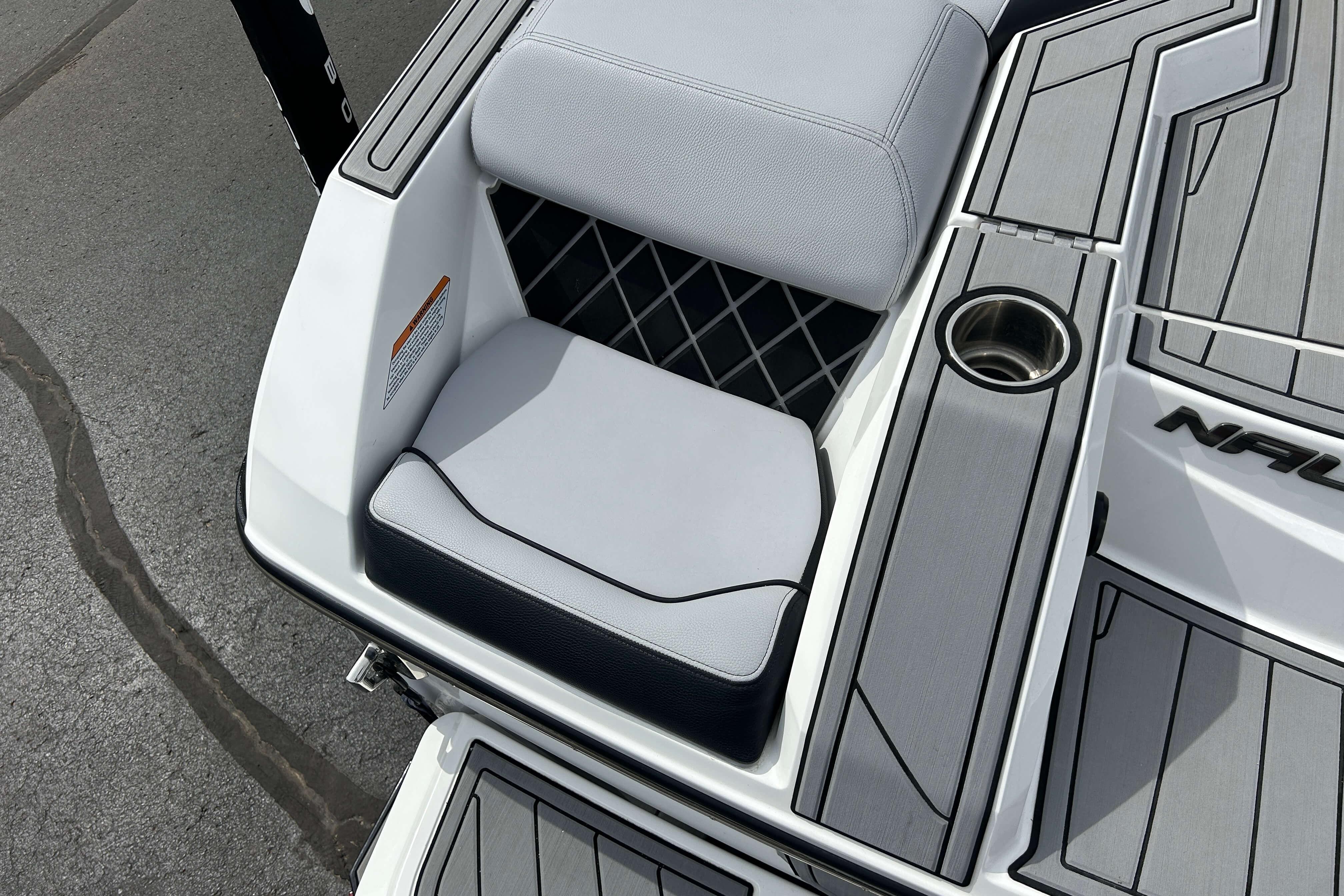 2021 Nautique Super Air Nautique GS24 boat interior with cushioned seating and cup holder.