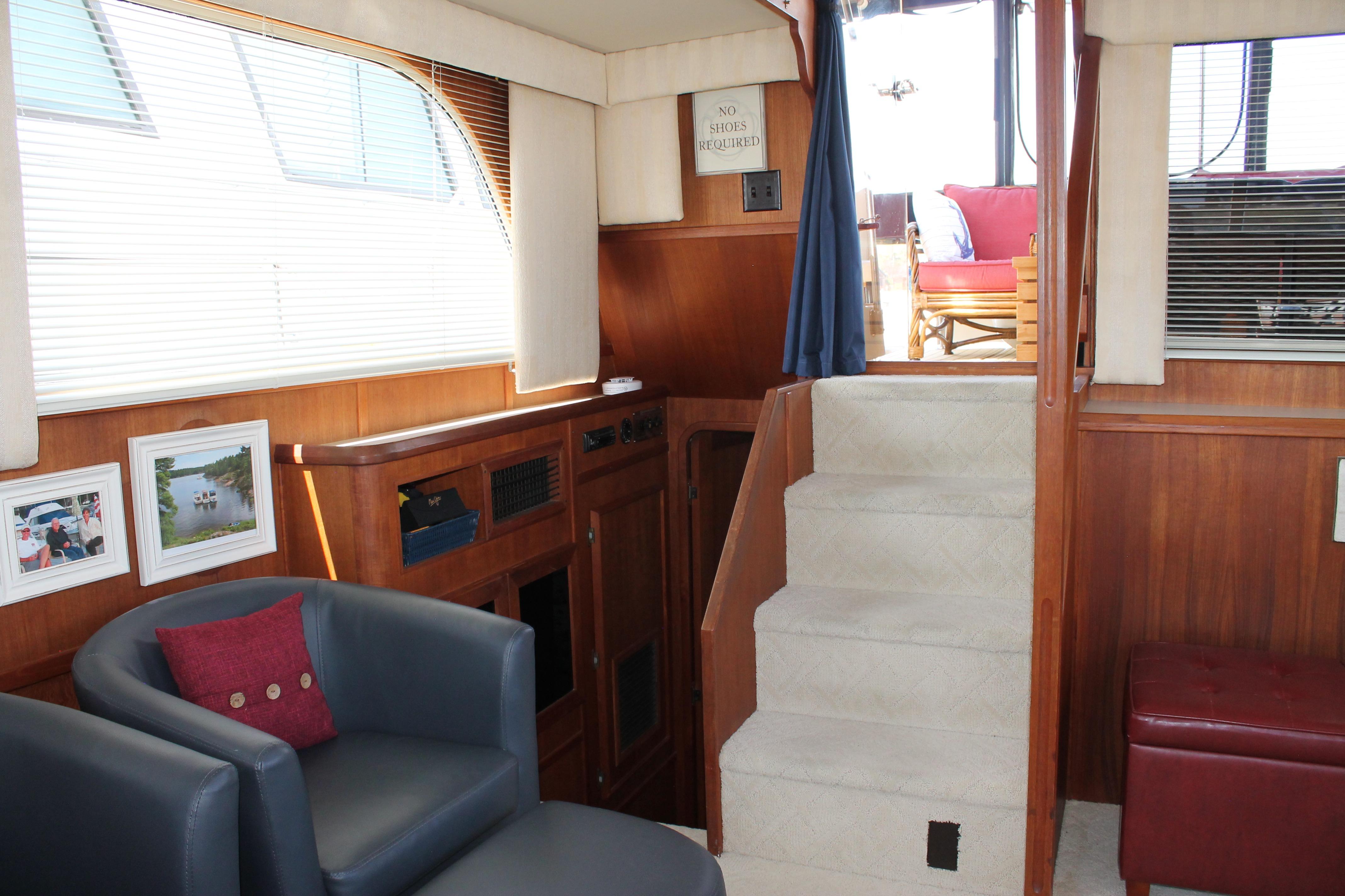 Interior of 1987 Chris-Craft 427 Catalina yacht with cozy seating and elegant wood paneling.