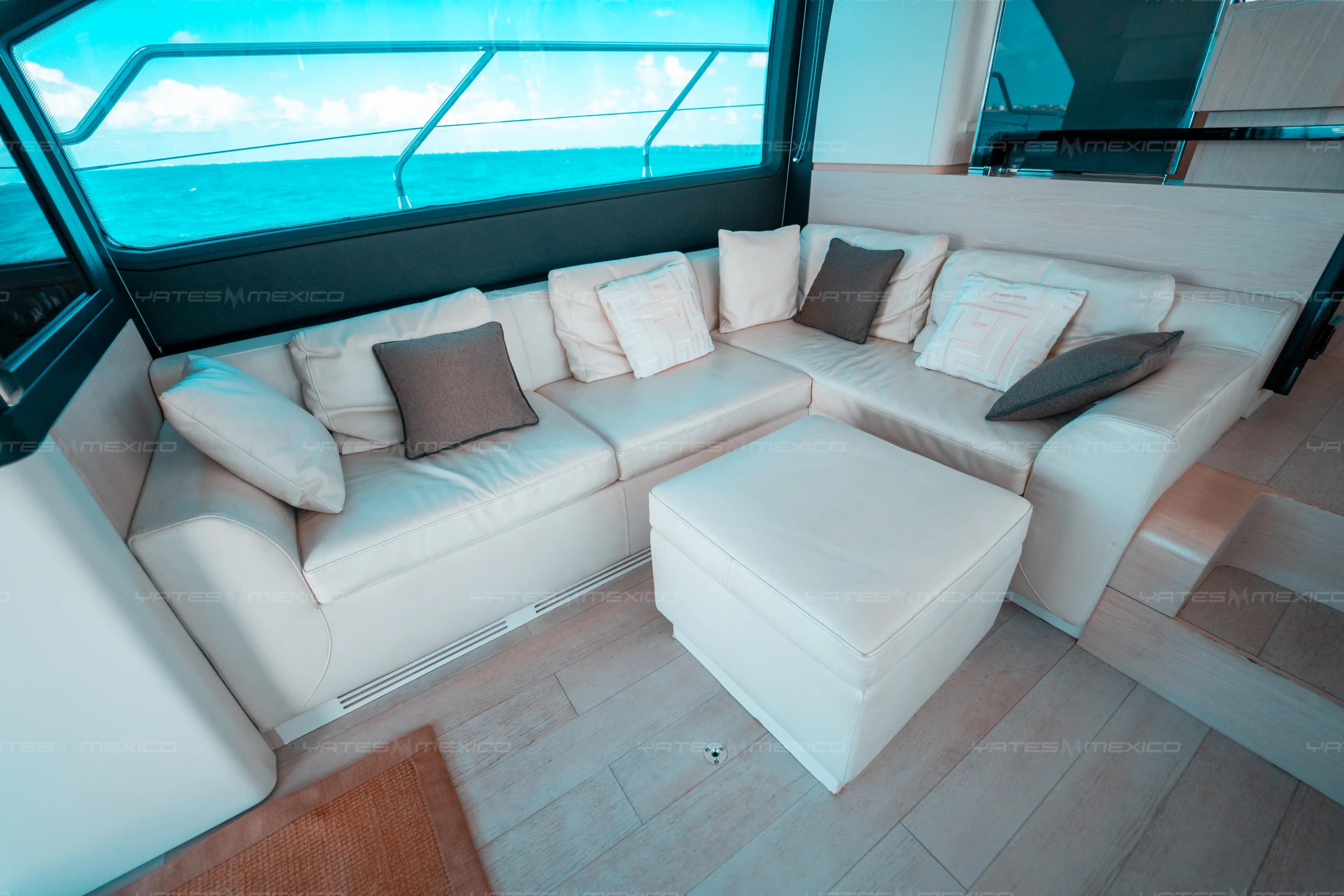 Luxurious interior of 2017 Azimut 66 yacht with plush white seating and ocean view.