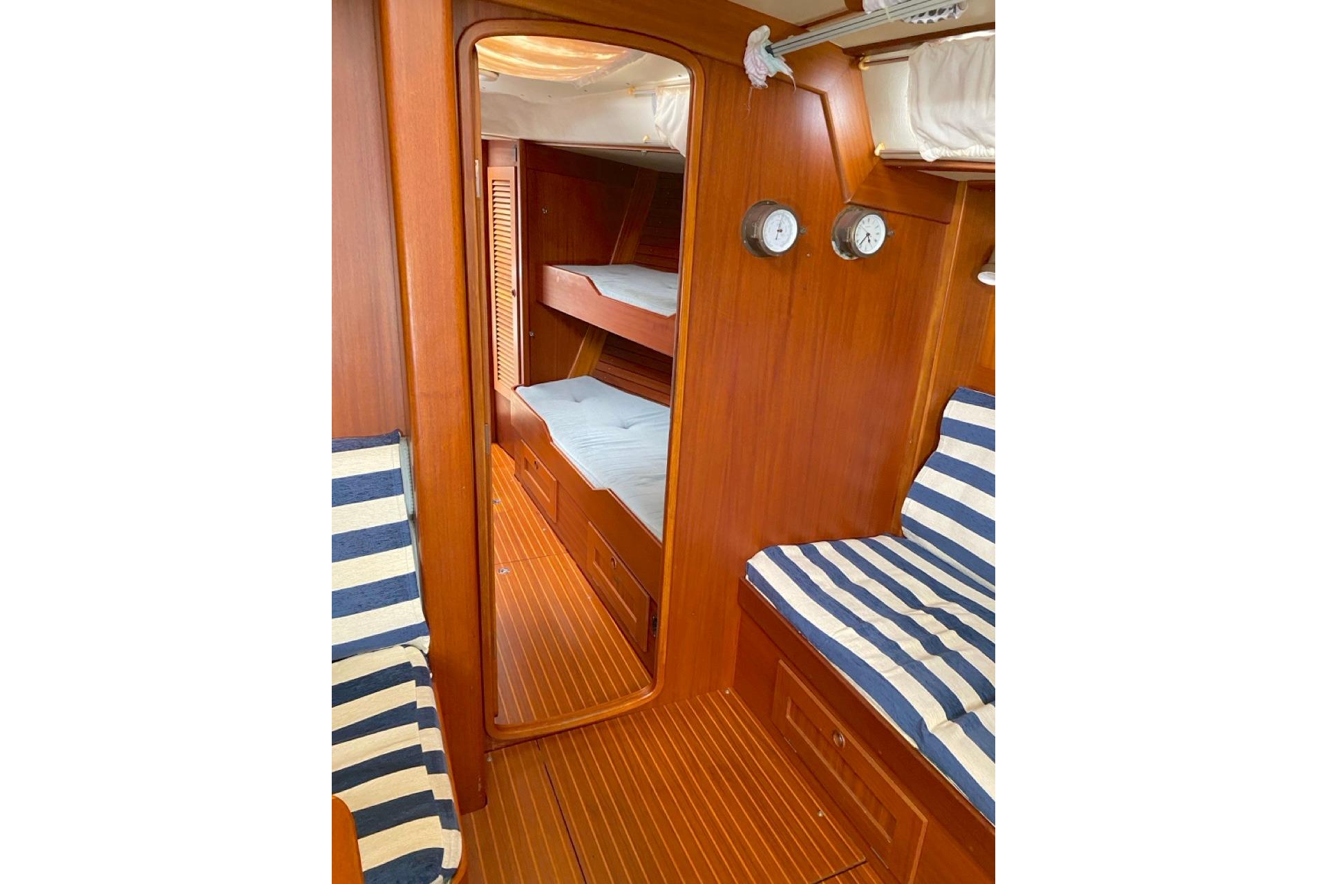 Interior of 1992 Hallberg-Rassy 45 yacht with wooden finish and striped seating.
