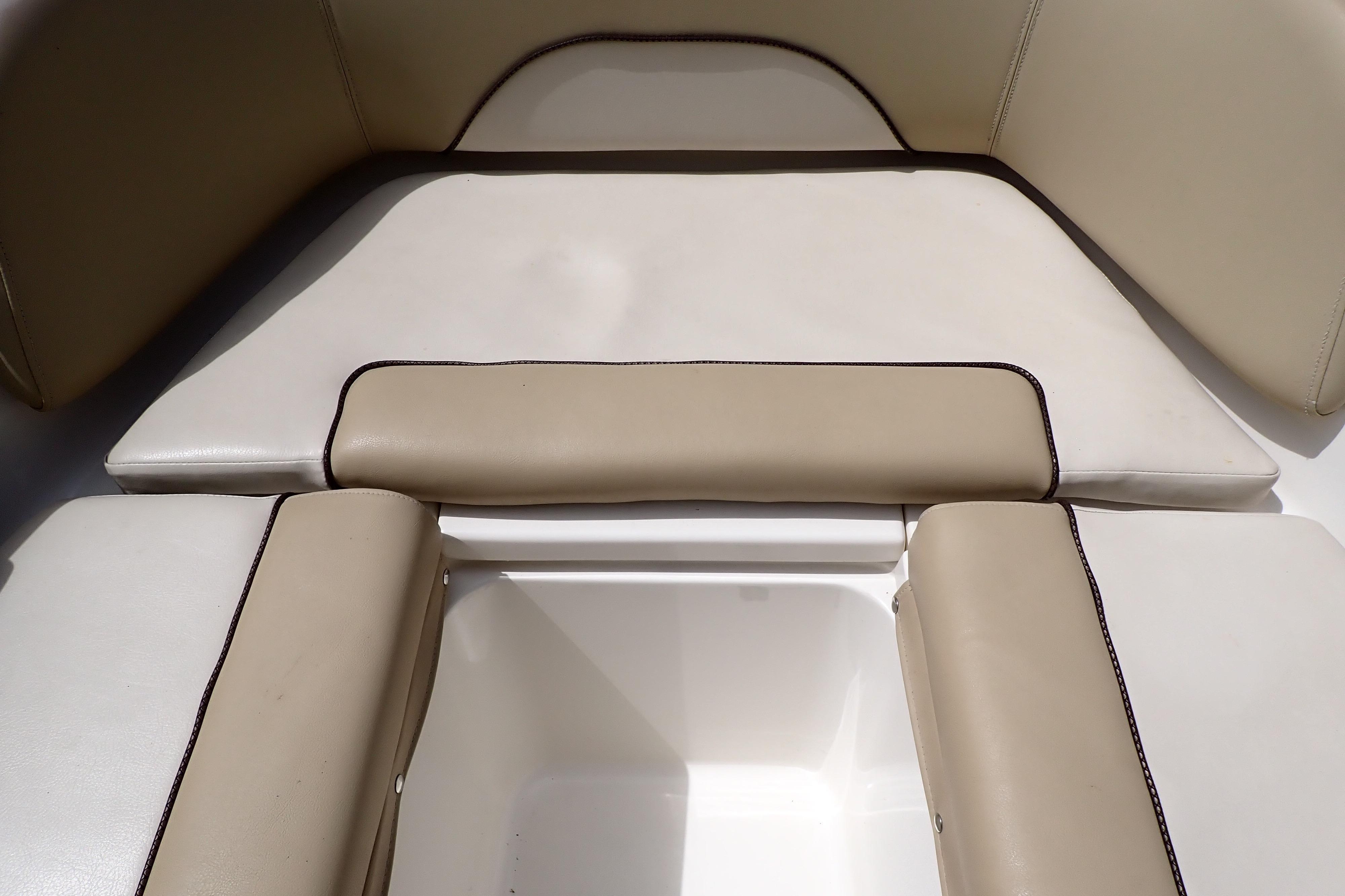 2019 Key West 263 FS boat seating area with beige cushions and storage compartment.