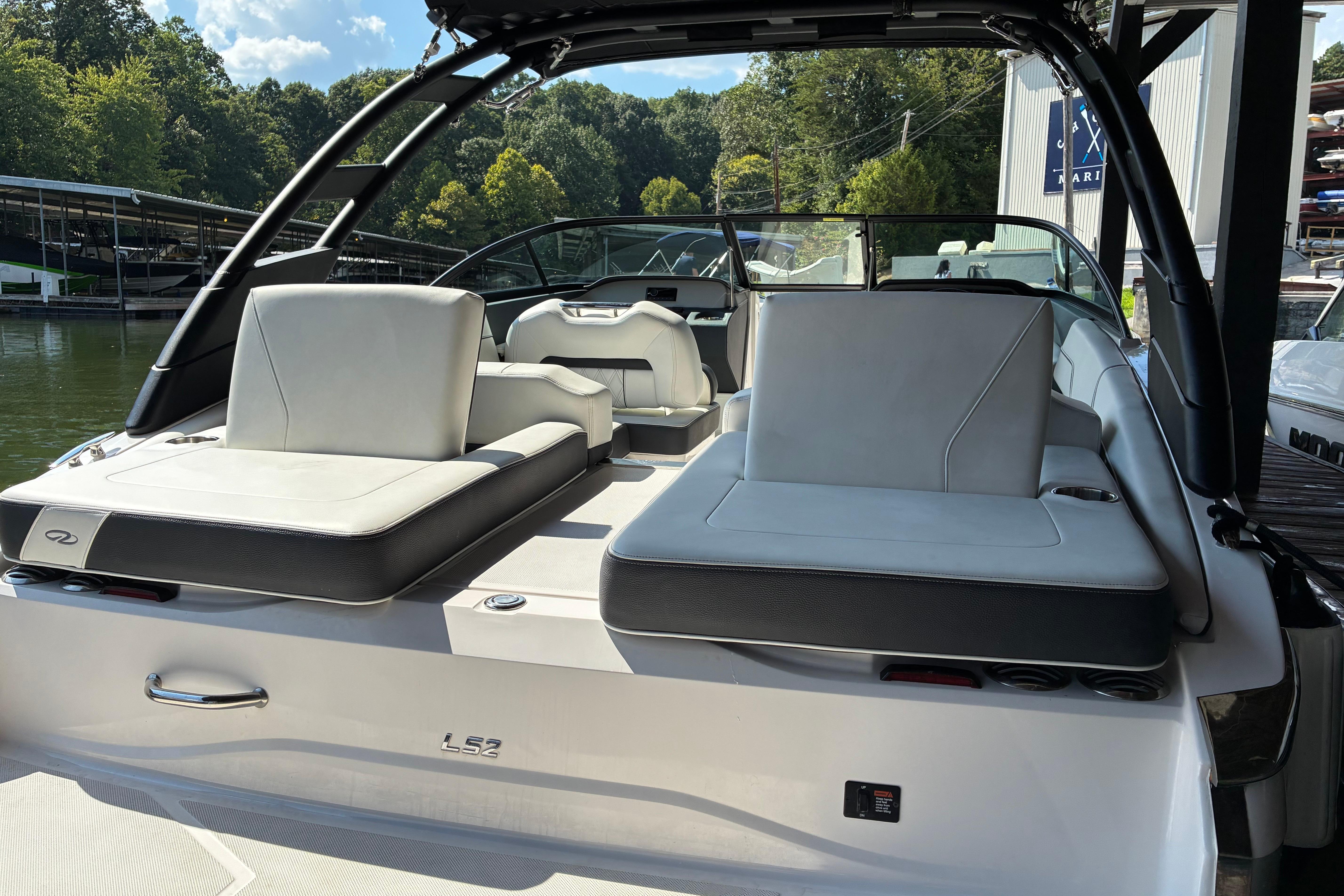 2025 Regal LS2 boat interior with sleek seating, docked by a scenic lake.