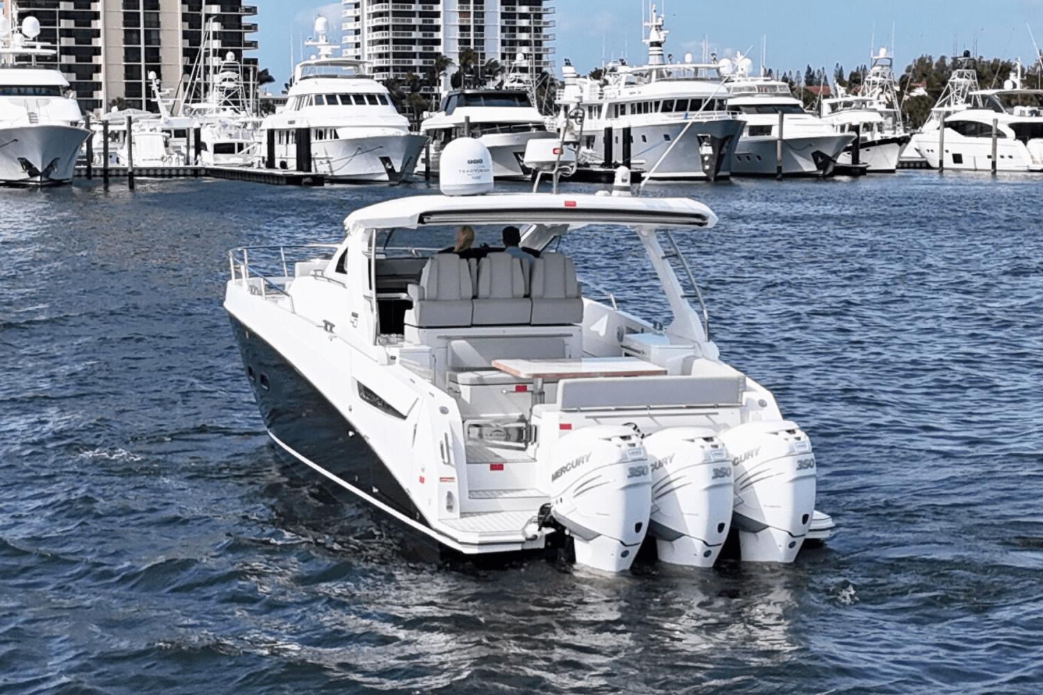 Azimut 40 Verve 2020 yacht cruising in a marina with multiple boats docked.