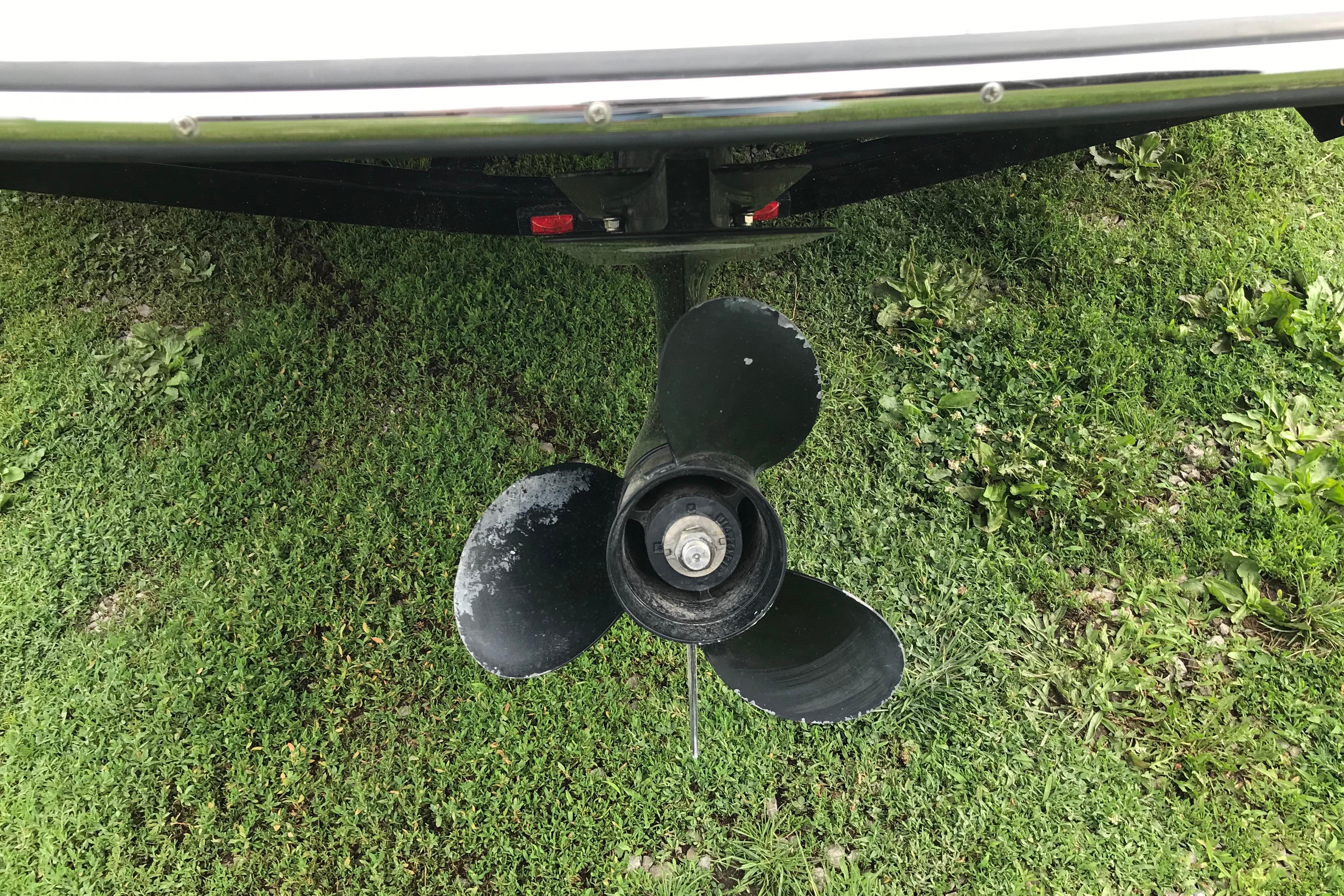 Propeller of a 2015 Crownline 18 SS boat on grassy surface.