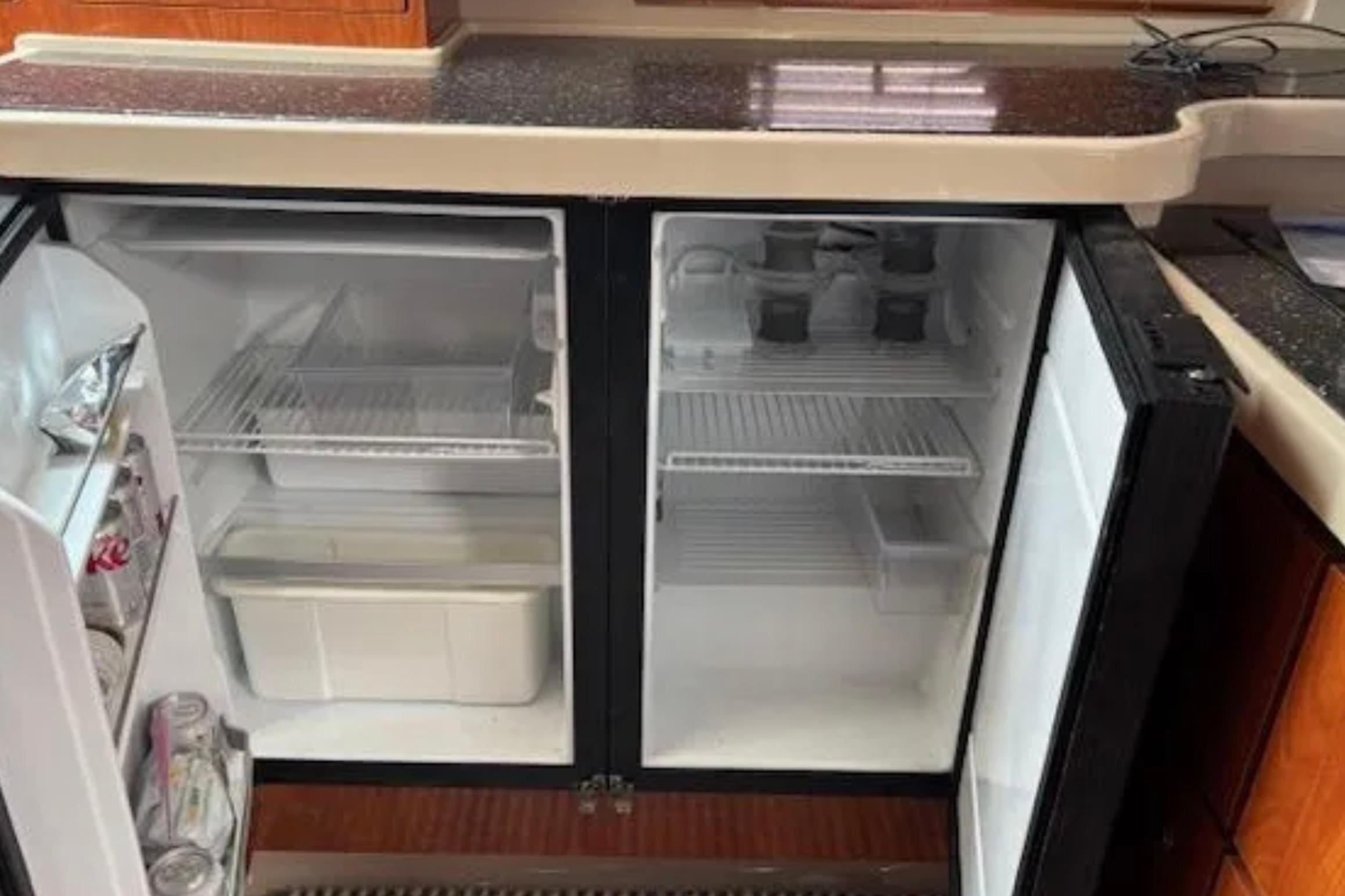 Refrigerator inside 2007 Four Winns 378 Vista yacht, open with drinks and storage.