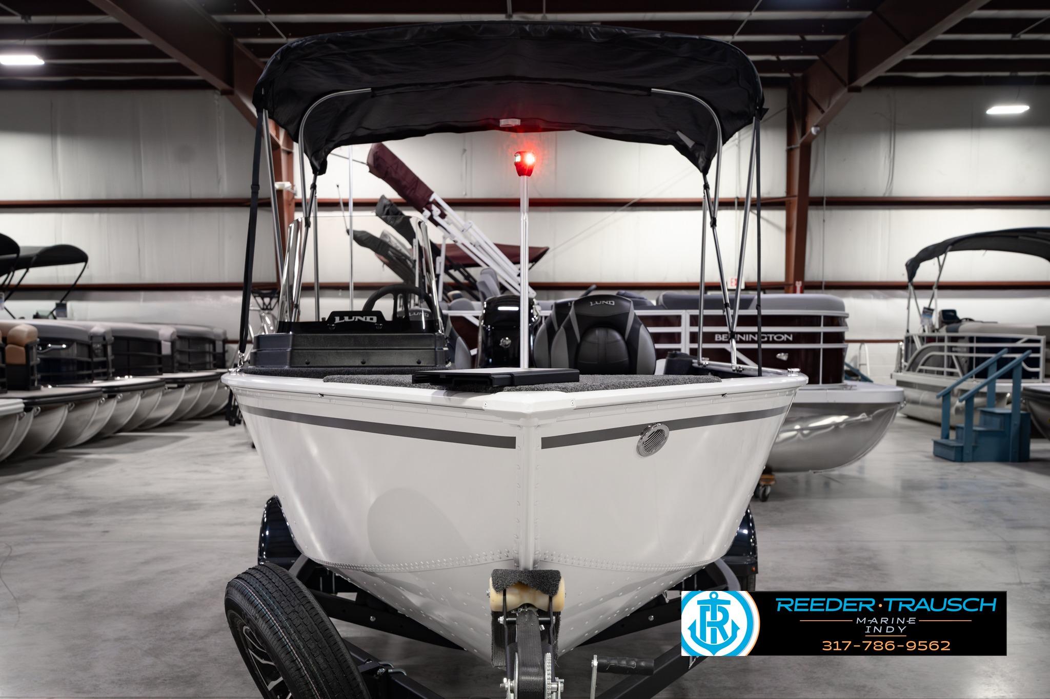 2026 Lund 1650 Rebel XL SS boat in showroom, featuring sleek design and canopy.
