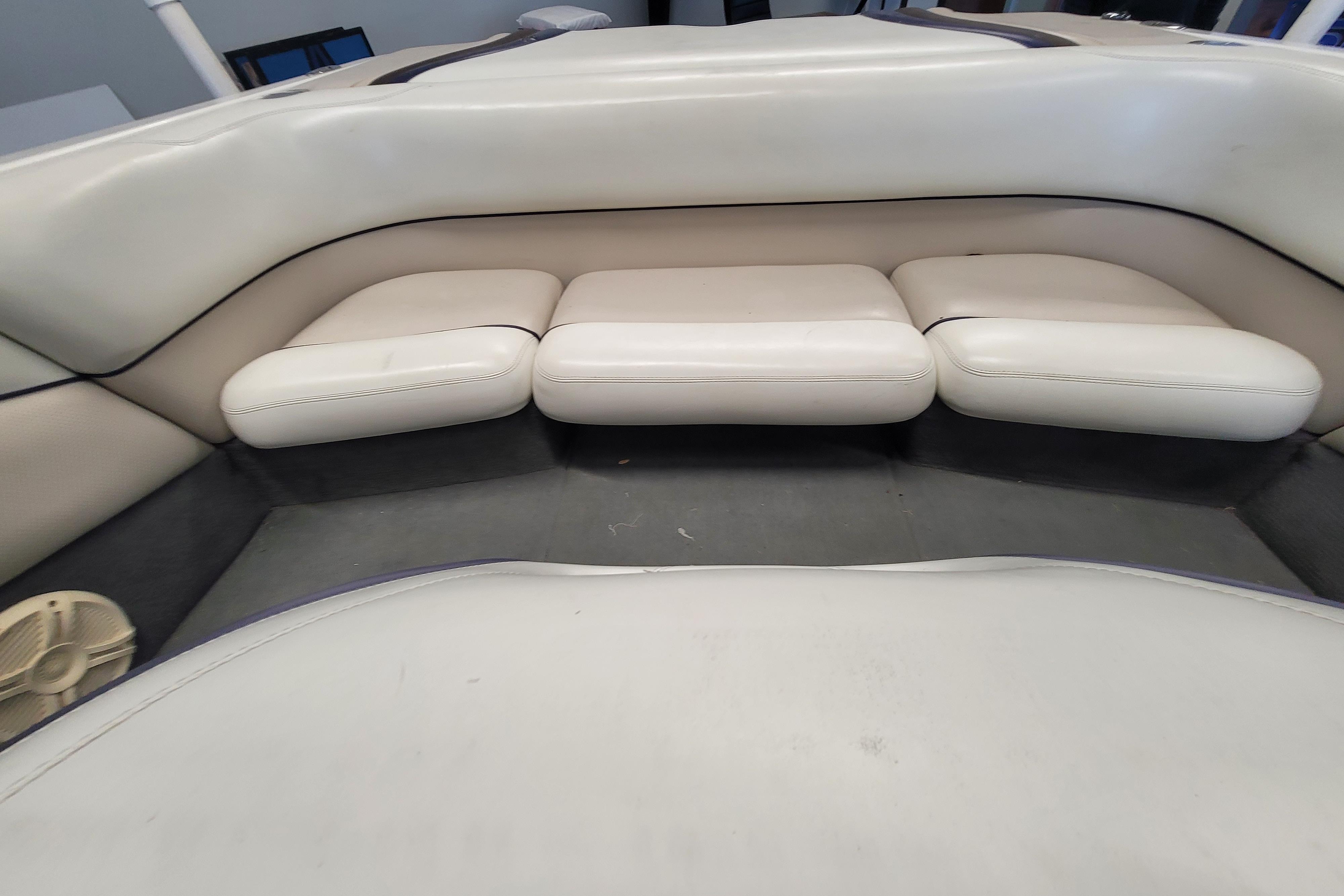 2003 Malibu Sunsetter LXi boat interior with white cushioned seating.