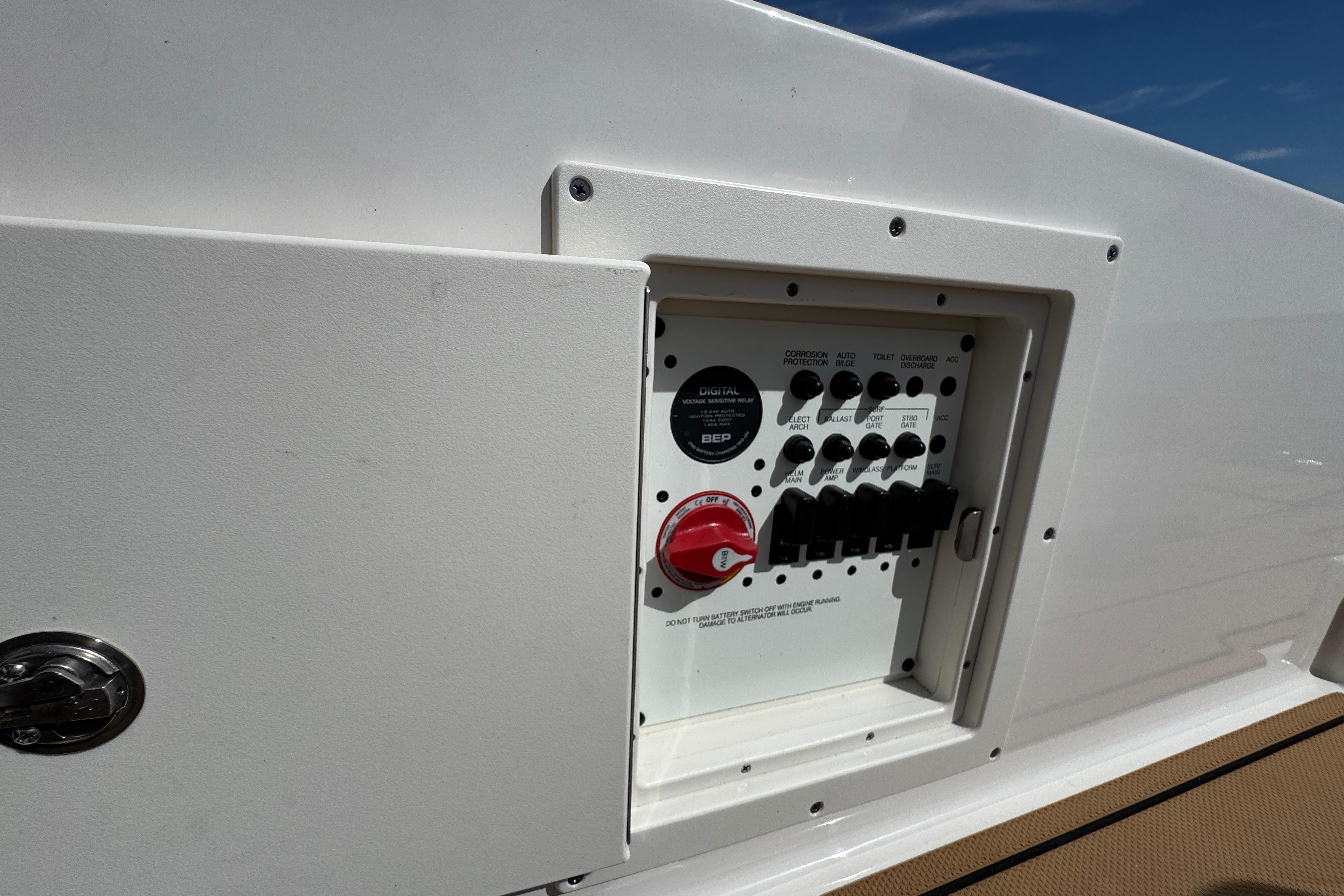 Control panel on 2023 Chaparral 26 Surf boat, featuring switches and a red dial.