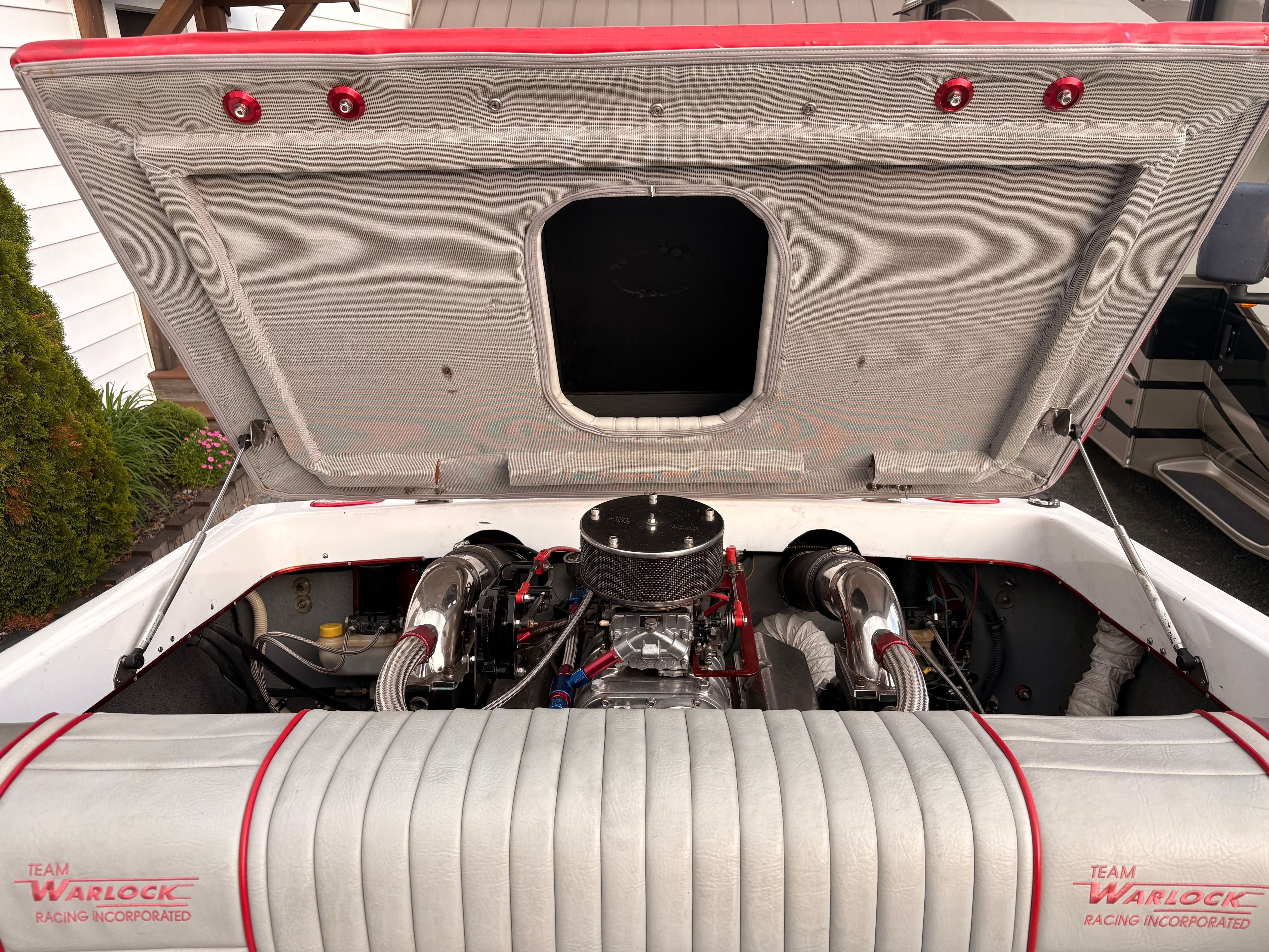 The engine compartment of a 1986 Warlock 23 is open, revealing the engine and wiring.