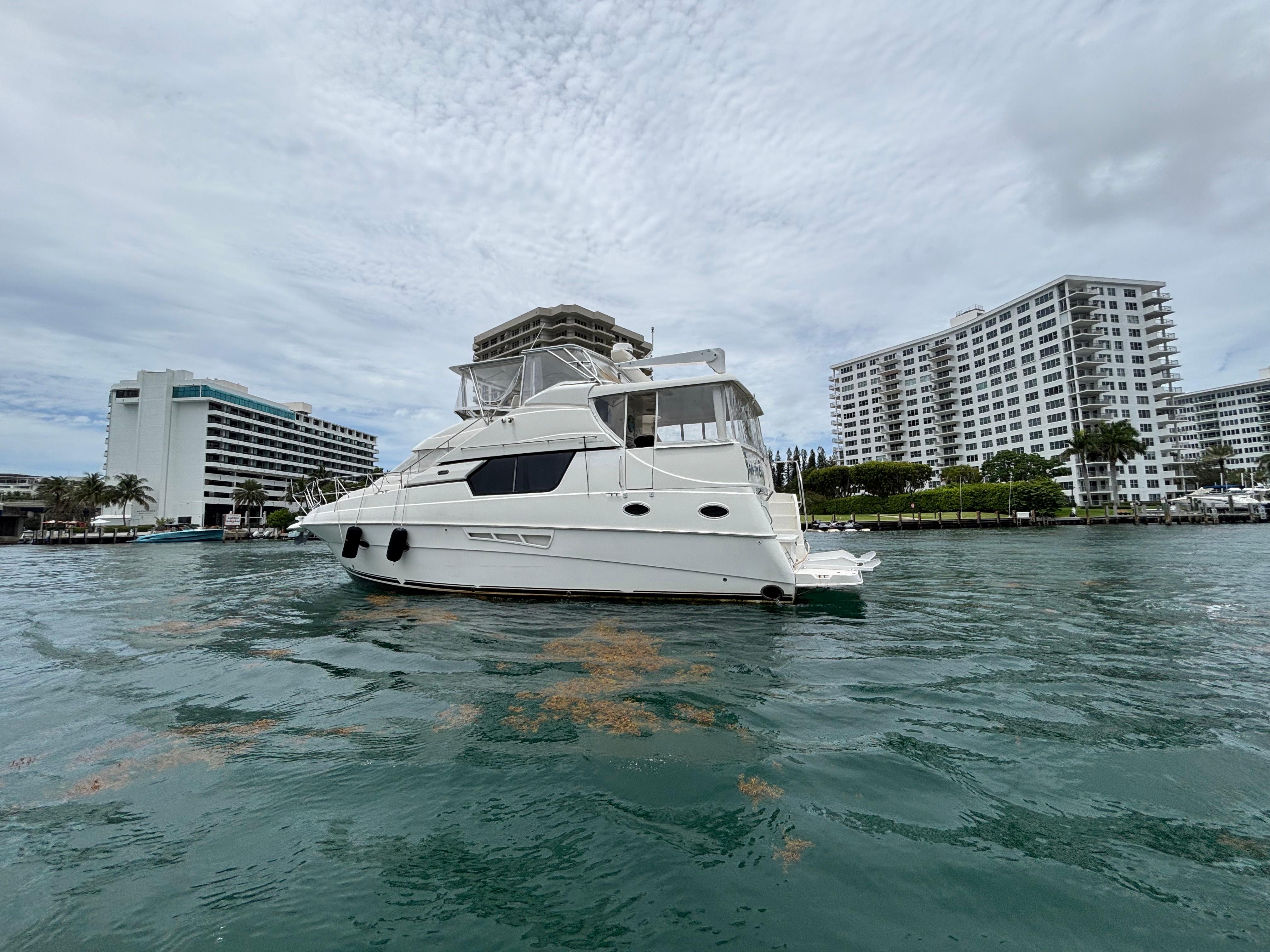 2000 Silverton 453 Motor Yacht on water near modern buildings.