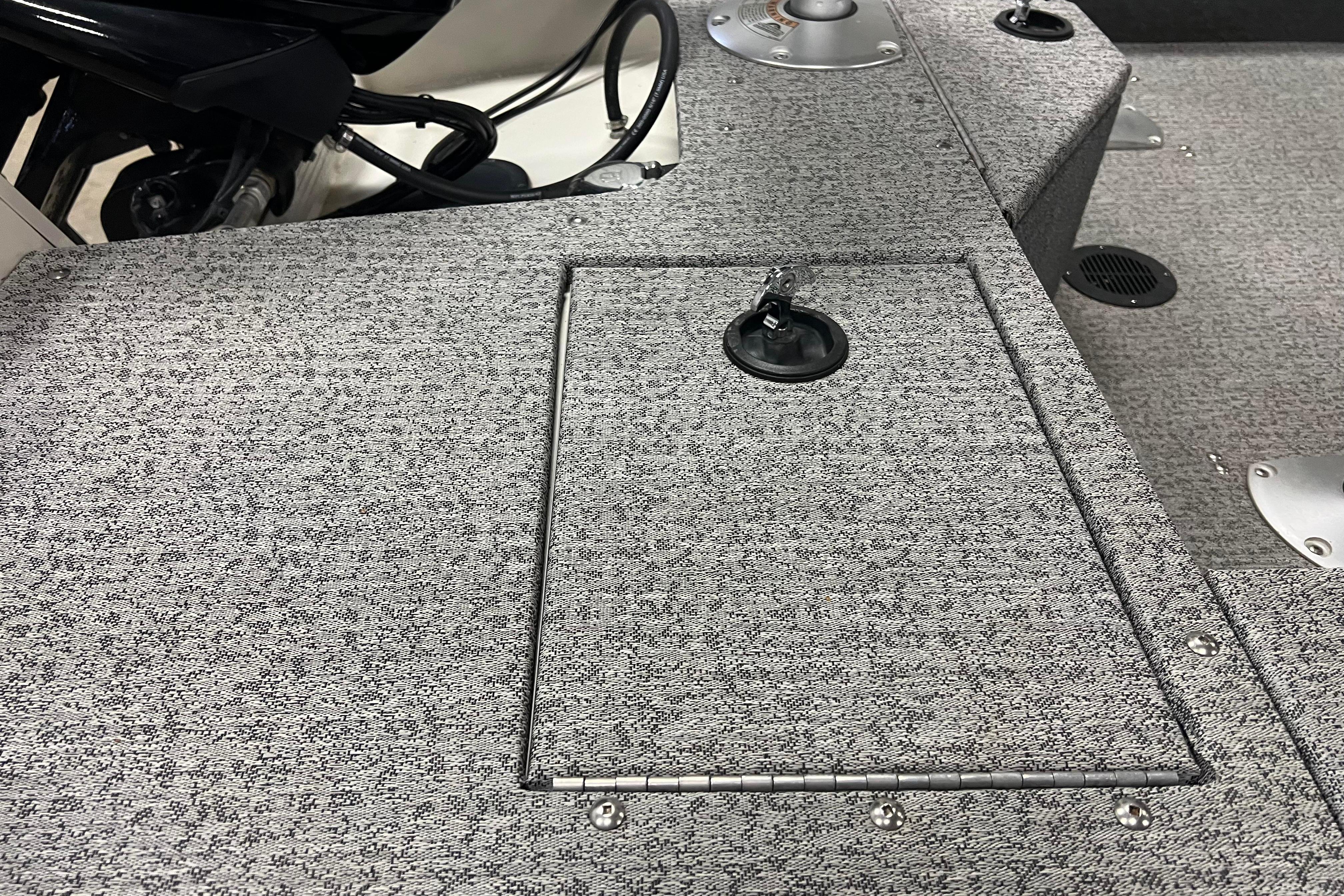 2022 Tracker Pro Guide V-16 WT boat deck with storage compartment and textured surface.