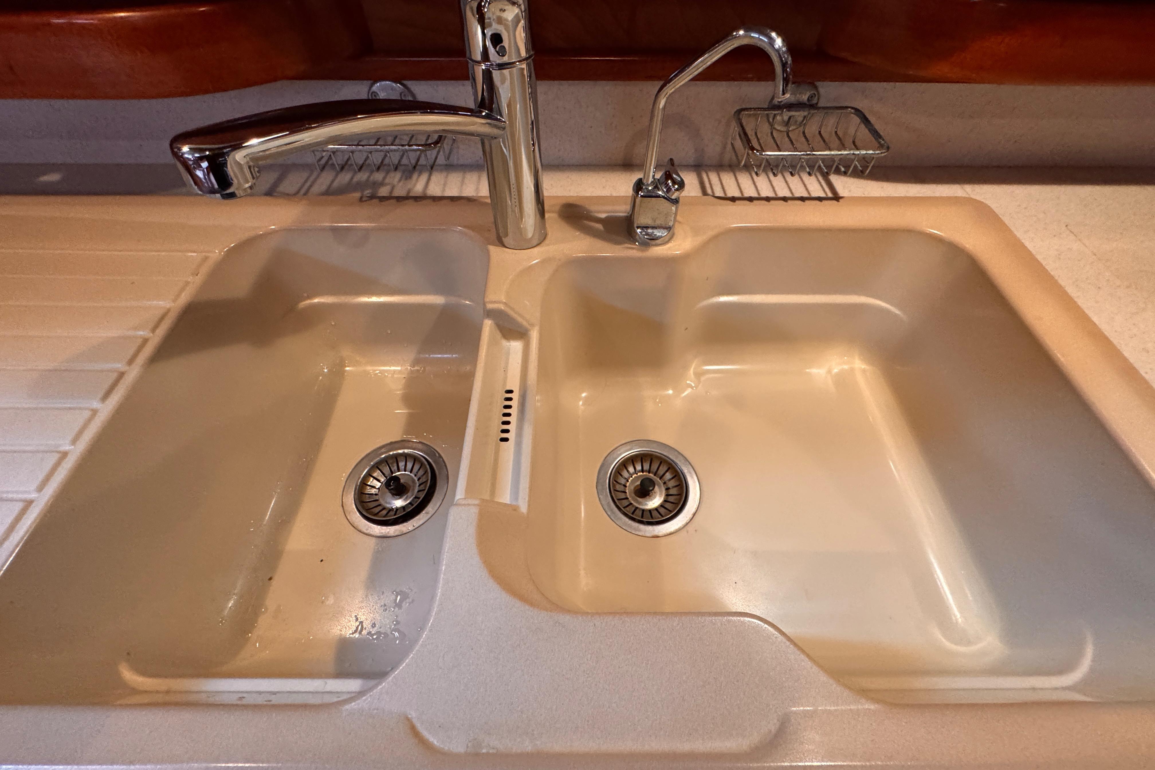 Double kitchen sink with chrome faucets on Amel Super Maramu 2000 yacht, 2004 model.