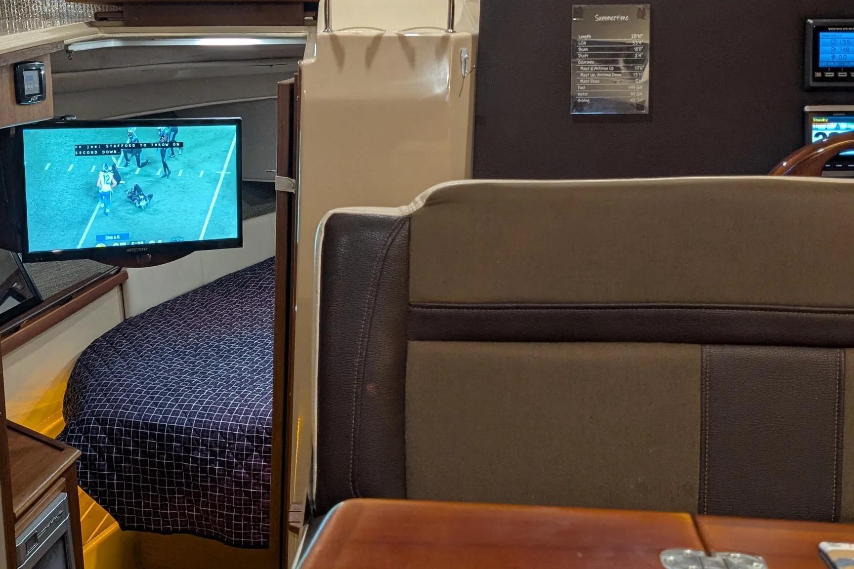 Interior of 2015 Ranger Tugs R-29 S with TV and cozy cabin bed.