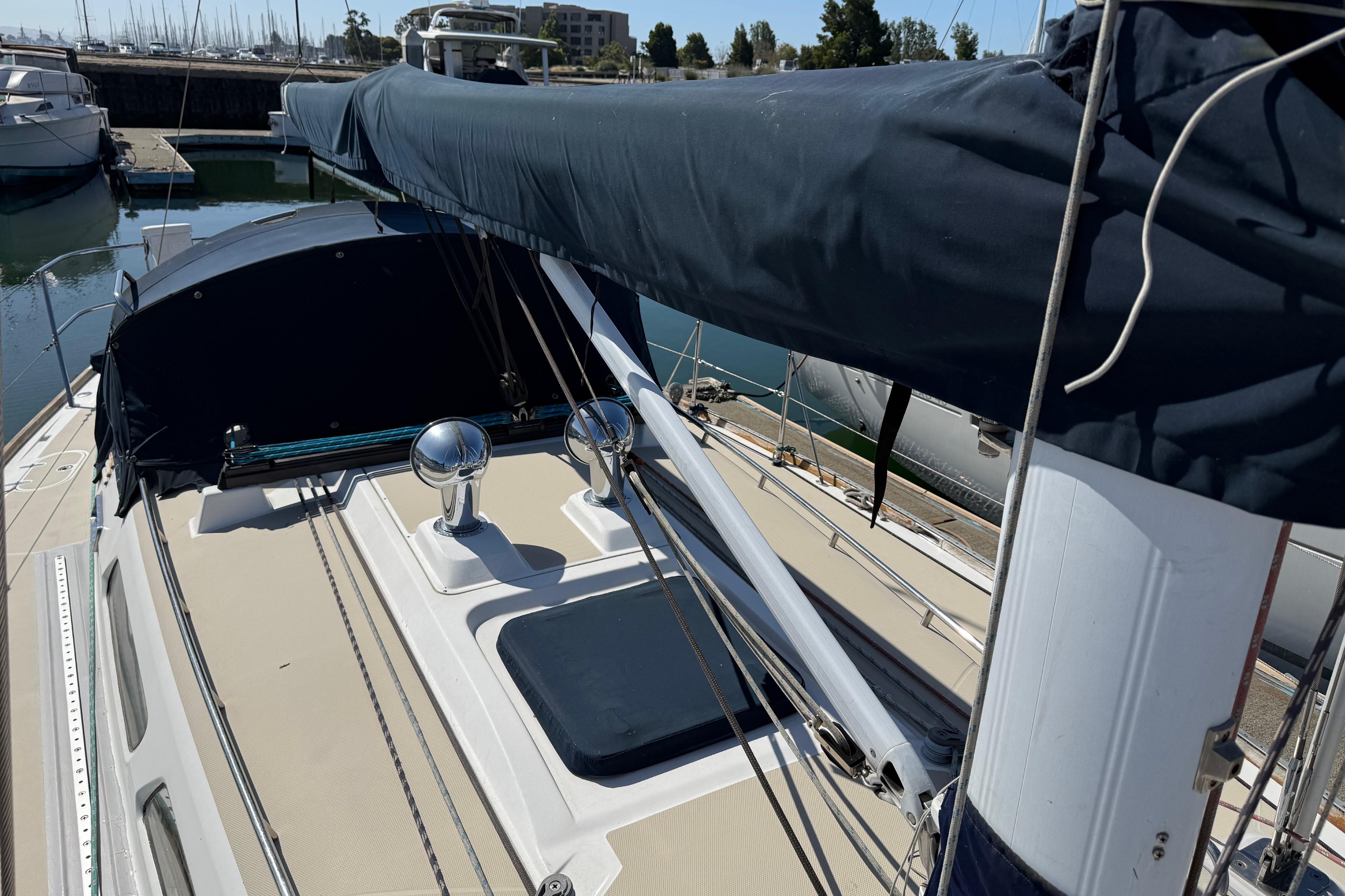 2004 Sabre 386 sailboat deck with covered boom, docked in marina.