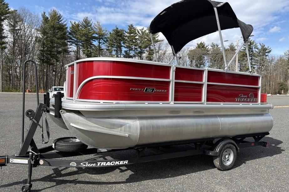 2026 Sun Tracker Party Barge 16 DLX pontoon boat on trailer, red and silver design.