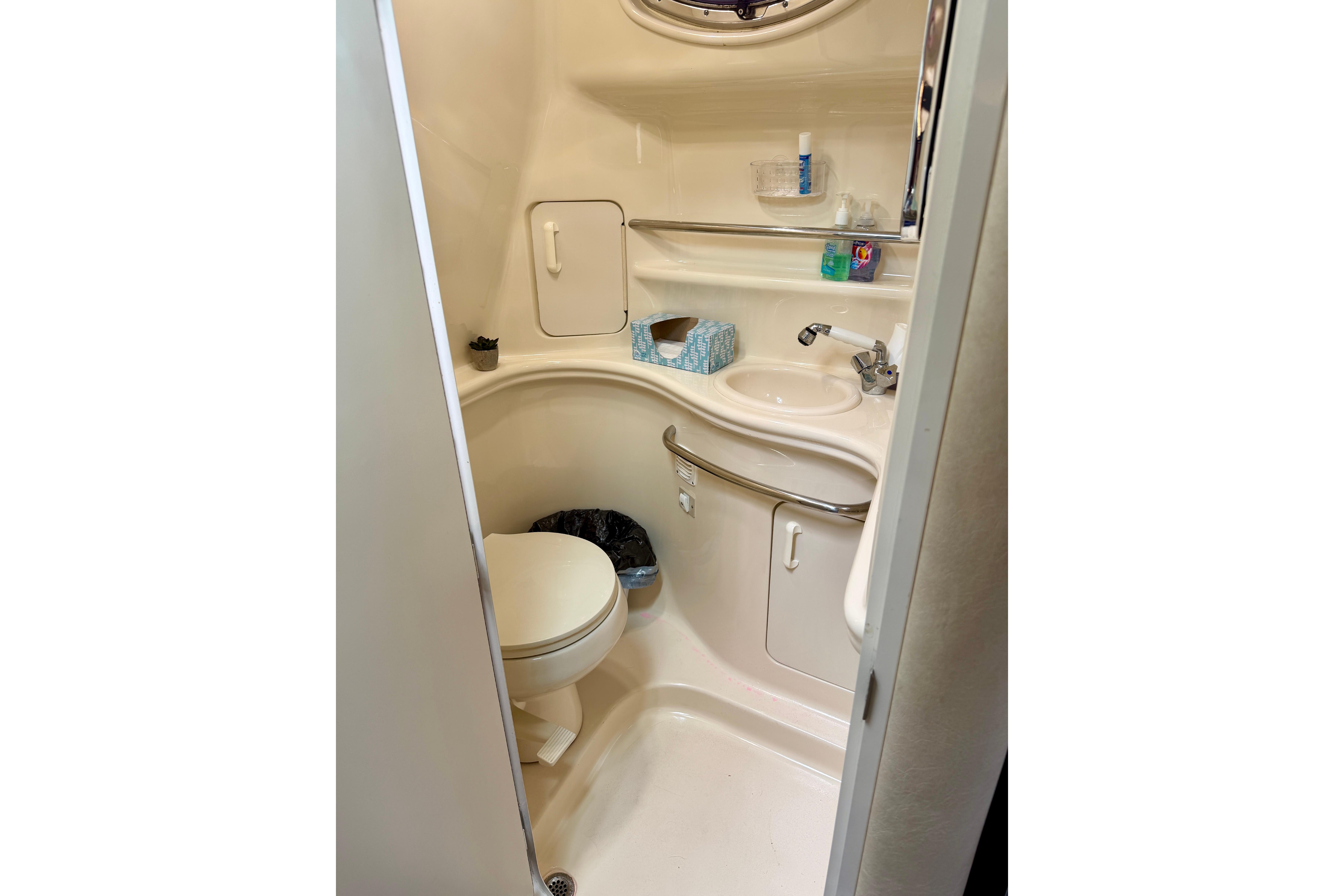 Compact bathroom in 2003 Sea Ray 340 Sundancer yacht, featuring toilet and sink.