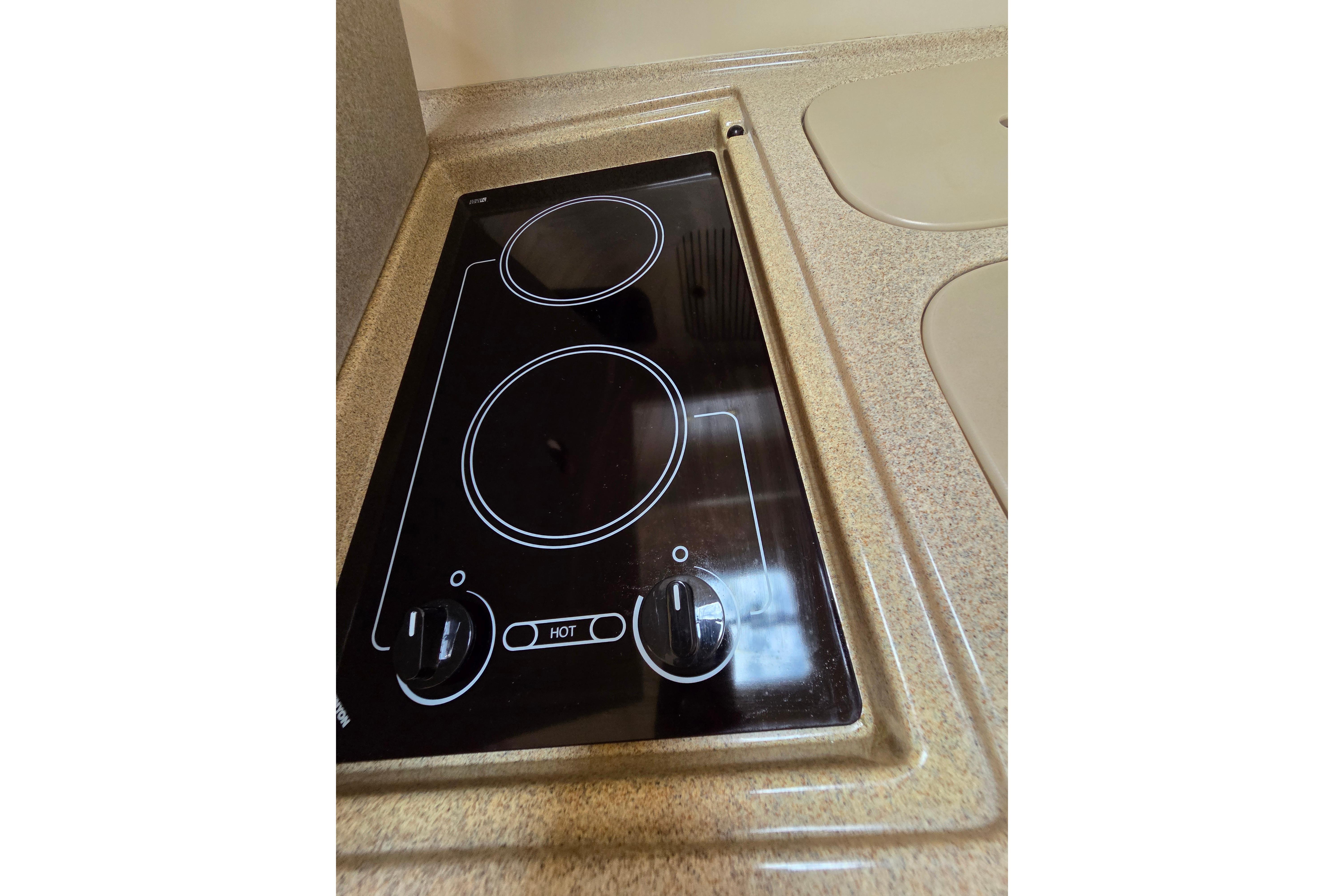 Stovetop in 2000 Sea Ray 340 Sundancer yacht kitchen, featuring dual burners.