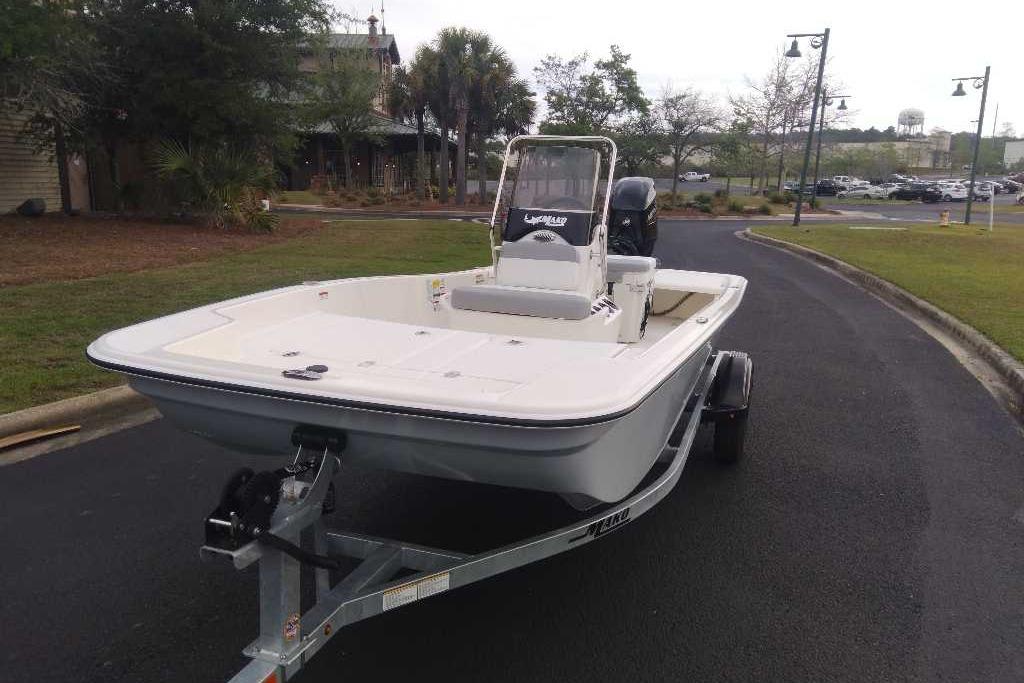 2026 Mako Pro Skiff 15 CC boat on trailer, parked on a paved road.